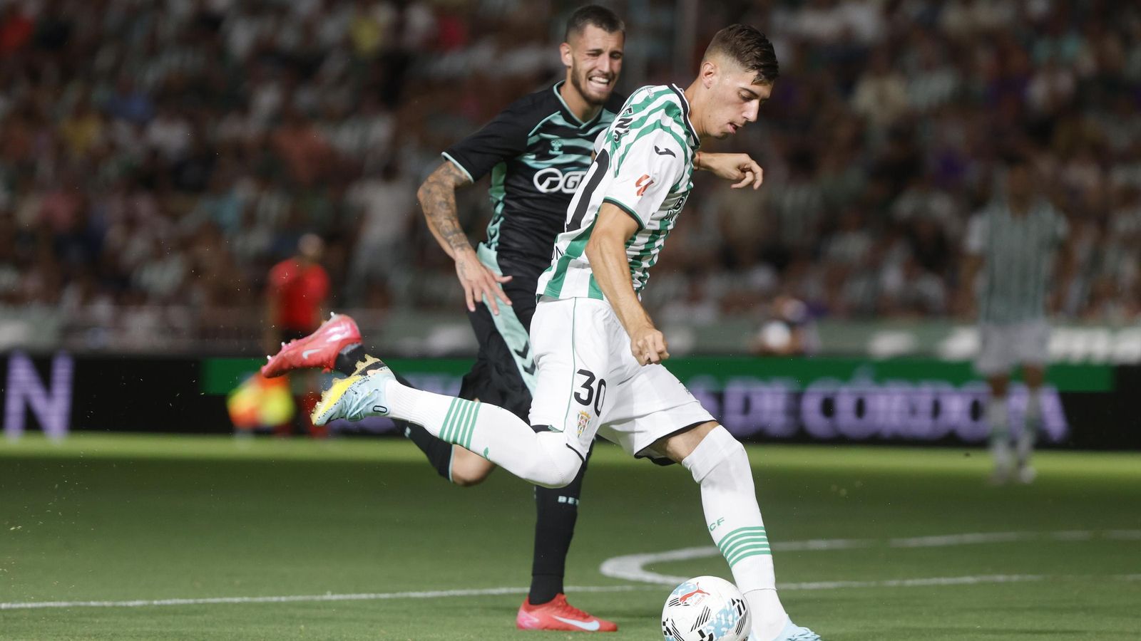 Requena golpea el balón en presencia de un jugador del Betis.