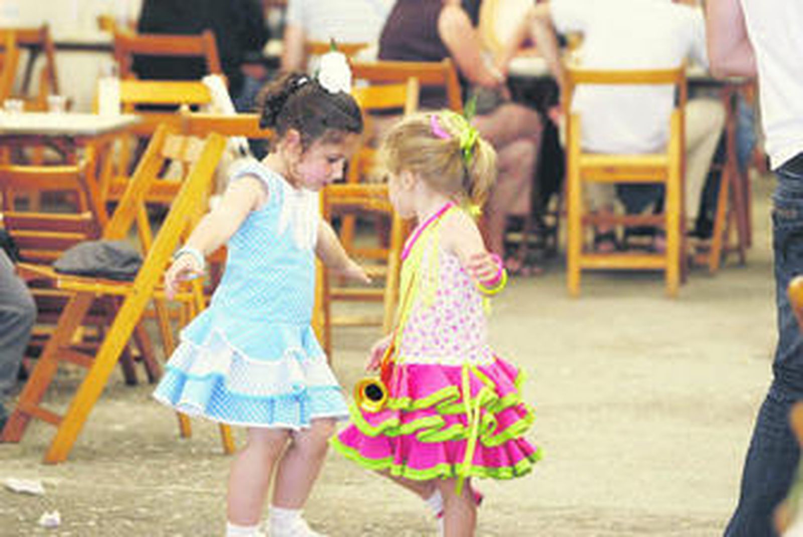 Dos niñas bailan sevillanas en el interior de una de las casetas del real de la Feria, en la Avenida del Mediterráneo.