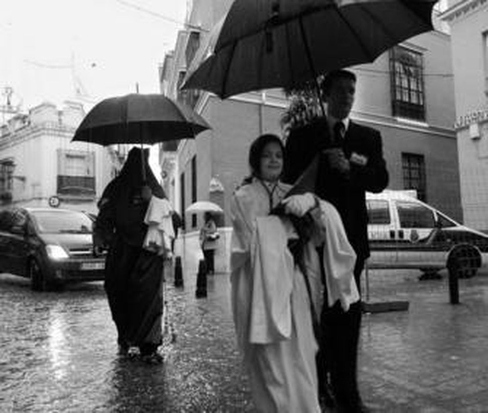 Una nazarena sale de San Martín cubierta por un paraguas.