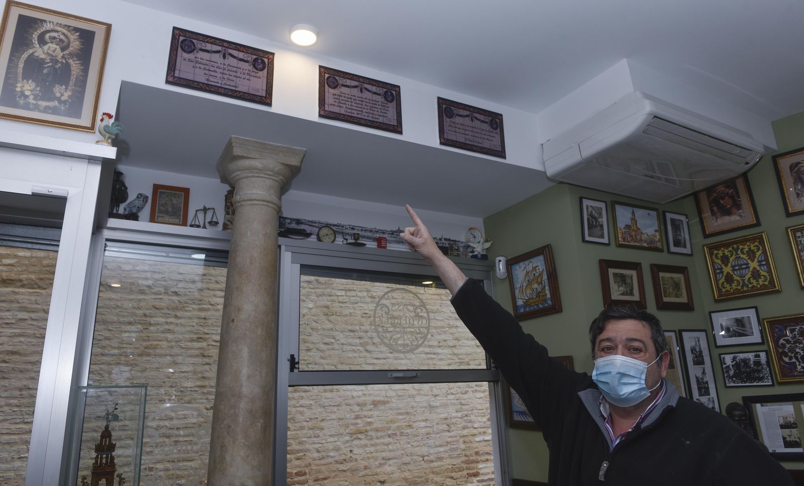 Joaquín Moreno enseña los tres azulejos sobre Cervantes pequeños que tiene en su abacería.