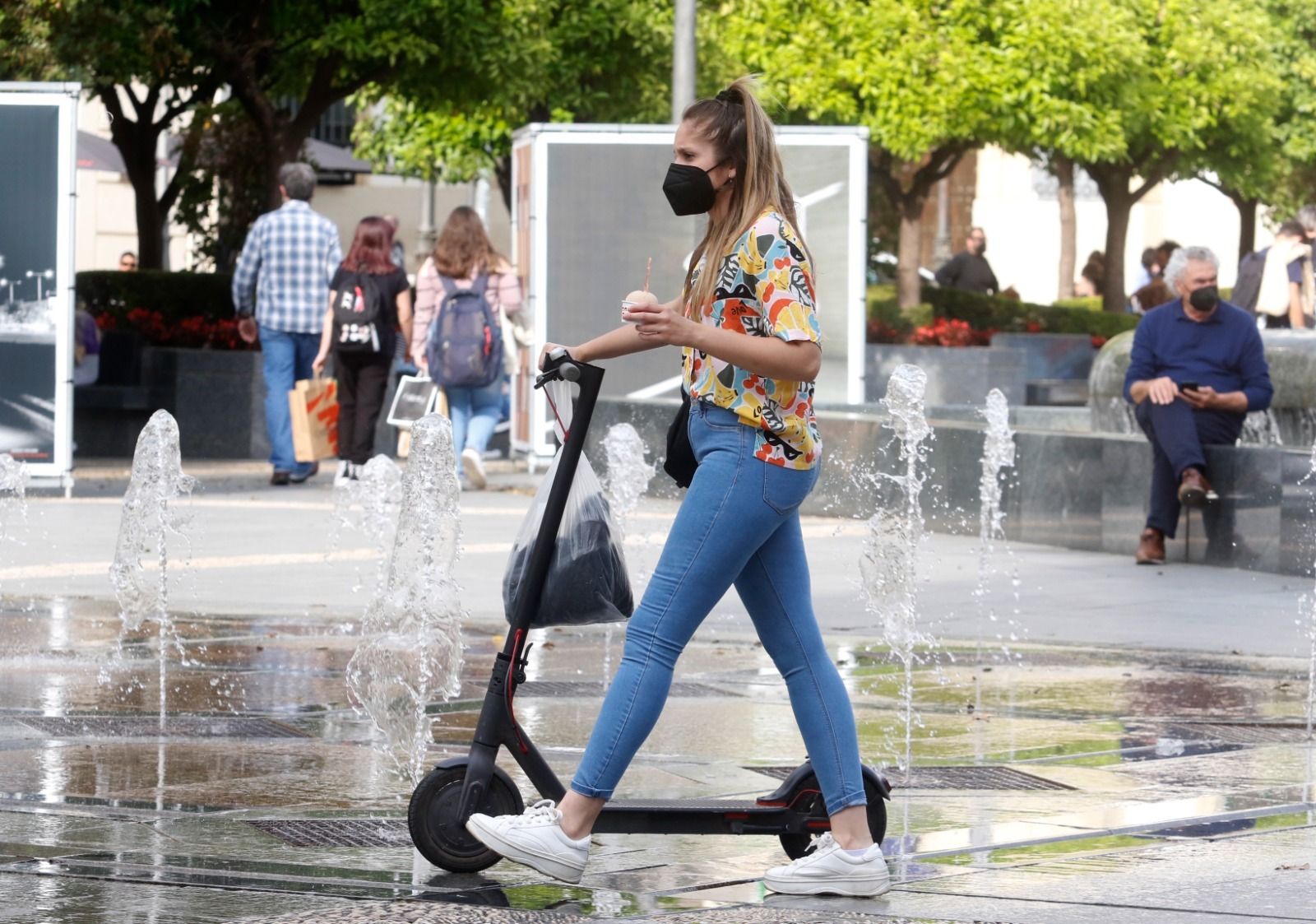 Una mujer en patinete por la plaza de Las Tendillas.