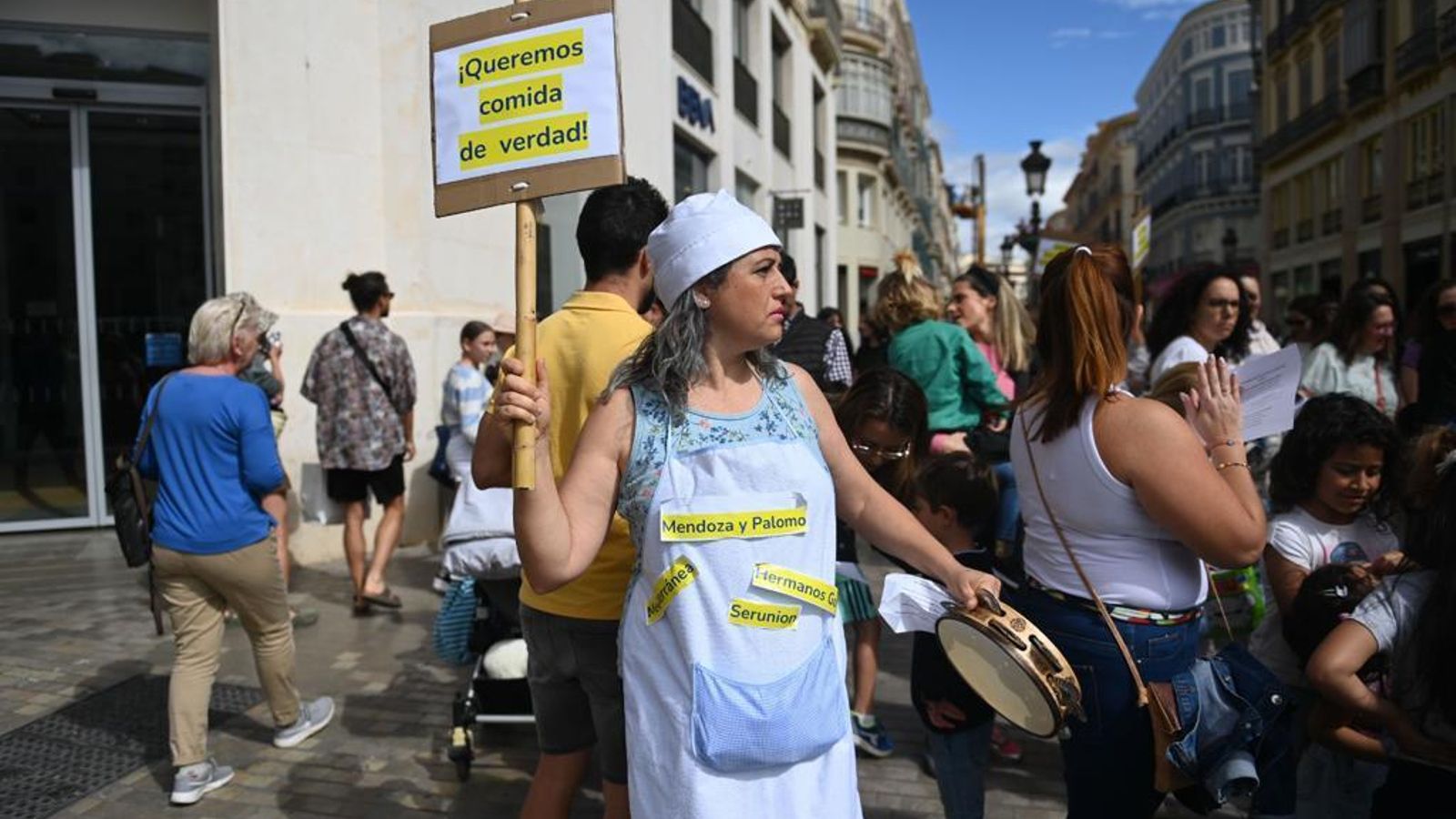 Una madre ataviada con gorro de cocina y delantal reclama preparaciones in situ en los comedores.
