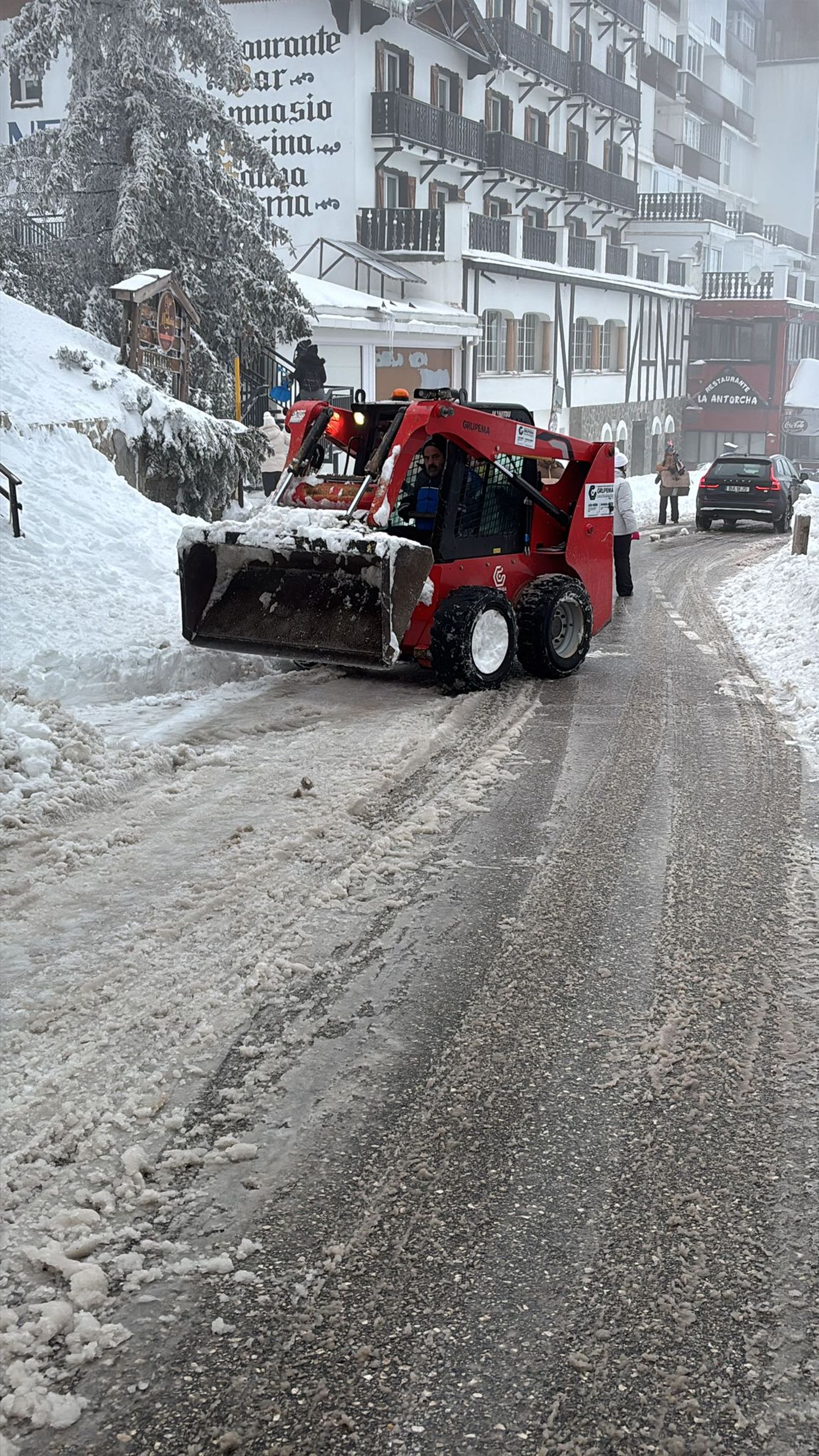 Varias personas tratan de despejar las calles de Pradollano.