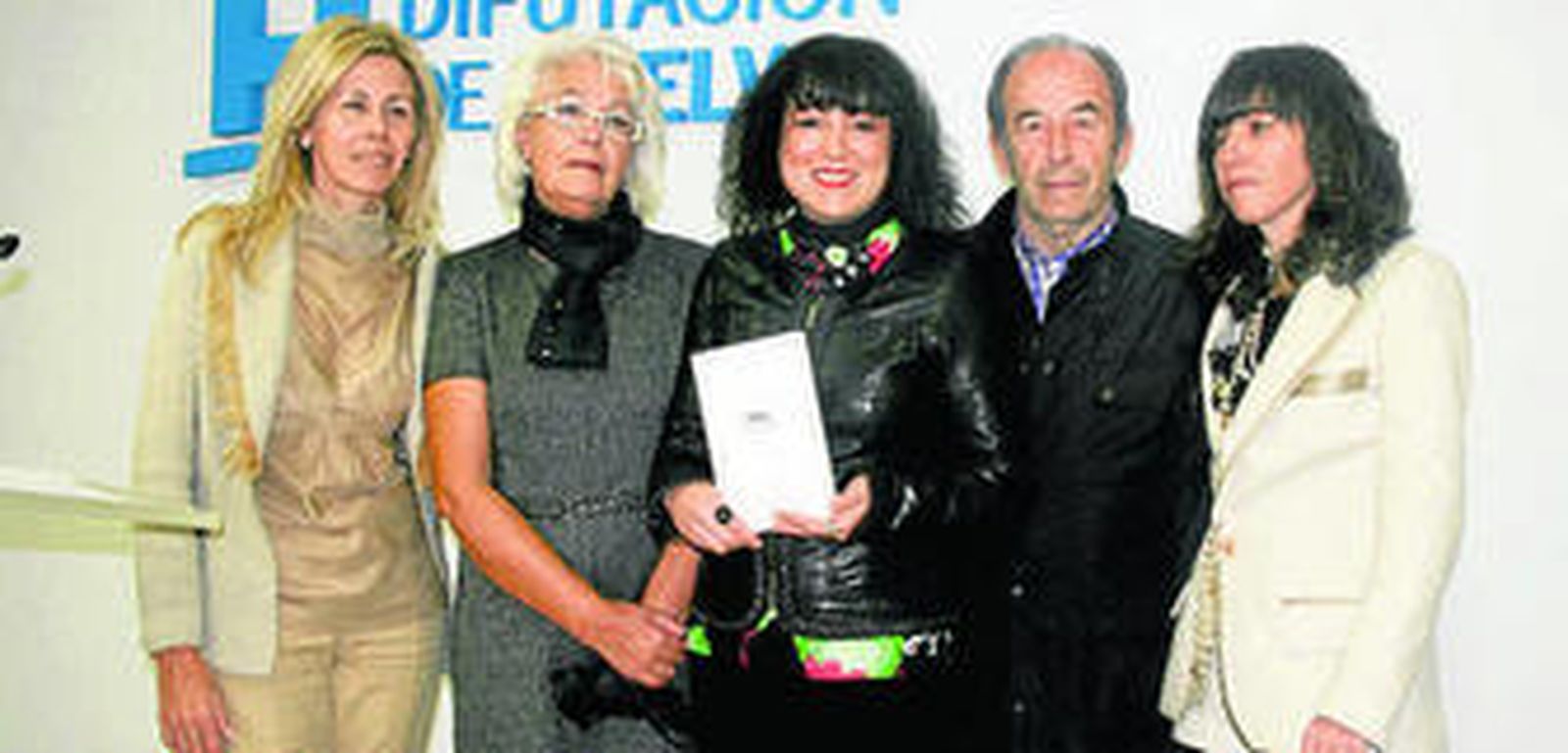 Elena Tobar, con el libro, acompañada de familiares de Carlos Rico.