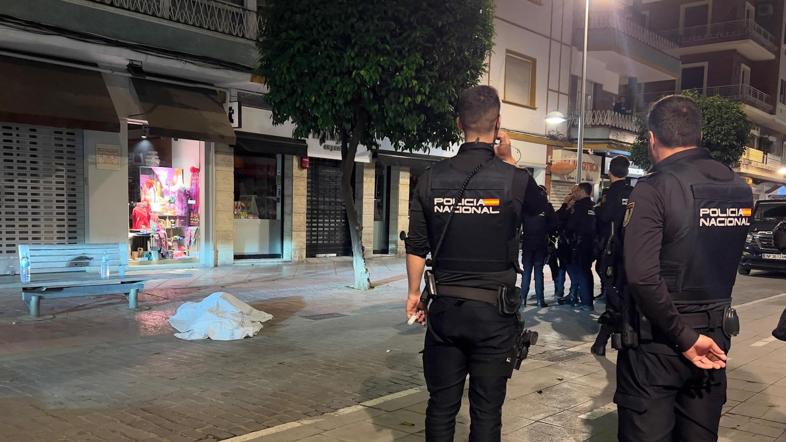 Policías nacionales junto al cadáver de un hombre en la calle Asunción.
