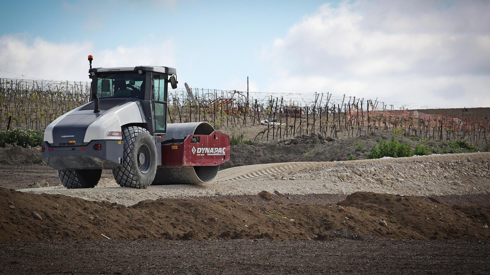 Una apisonadora allana uno de los caminos de acceso a las obras del parque eólico El Barroso.