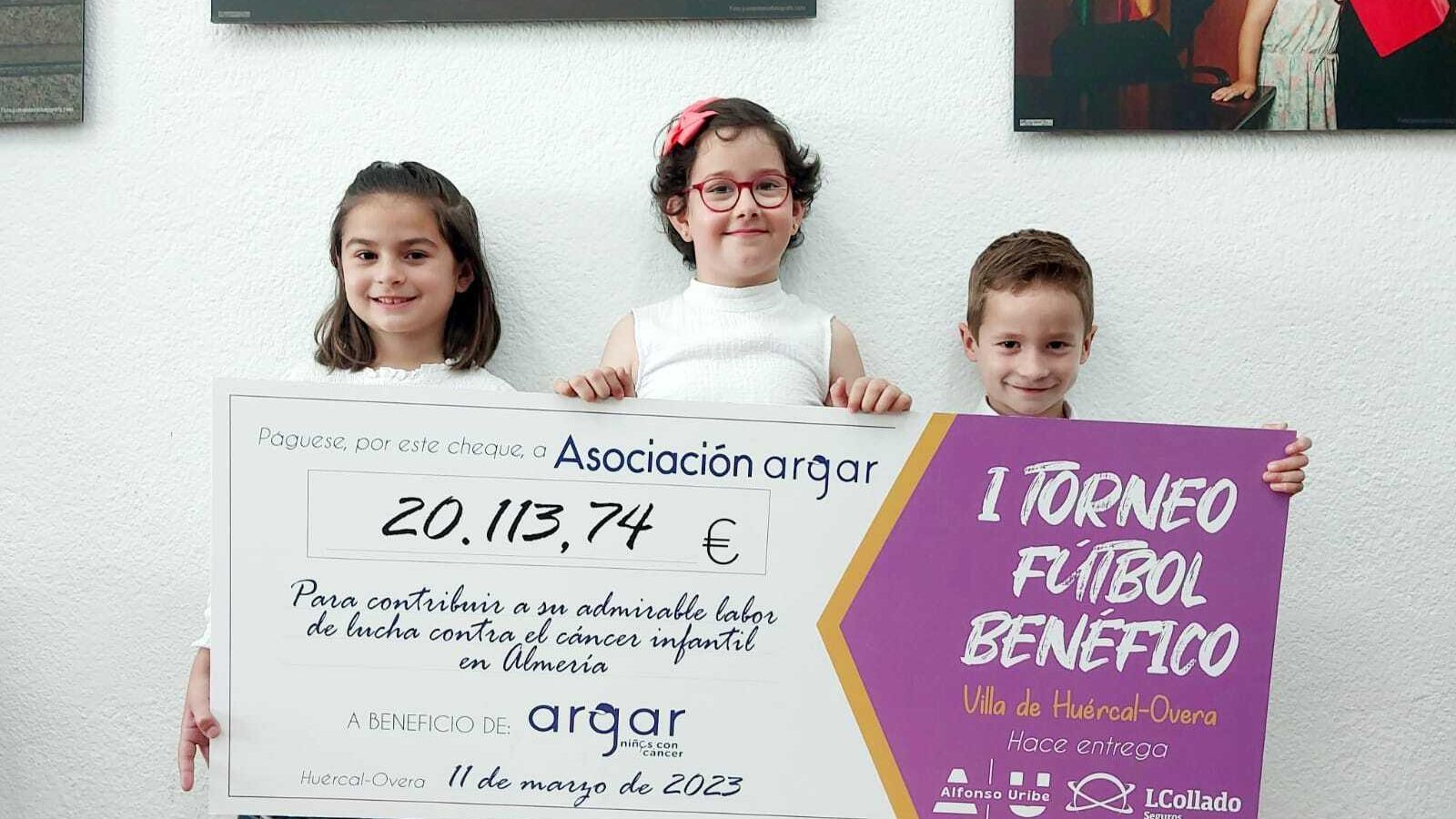 Los más pequeños muestran con orgullo el cheque.
