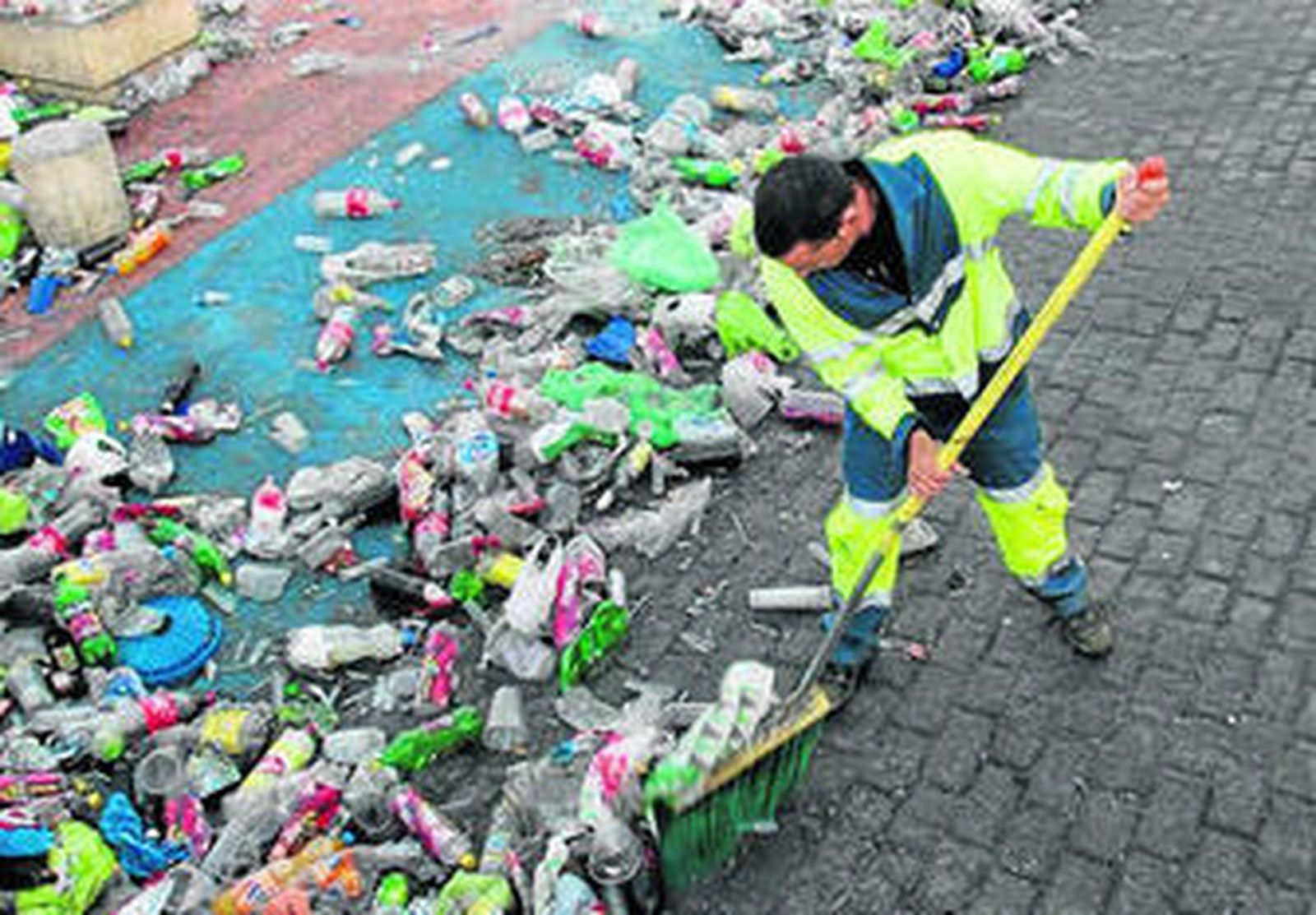 Un empleado de Inagra retira la basura acumulada en el botellódromo.