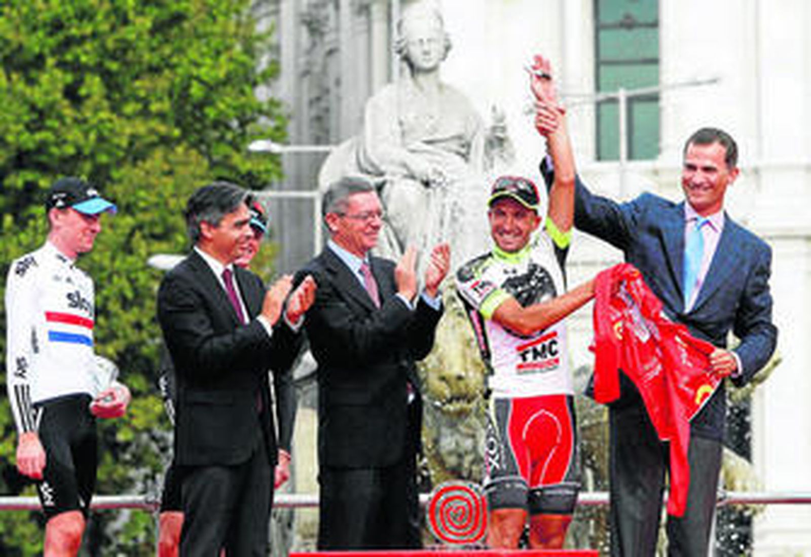 Juan José Cobo, en el momento de regalar el maillot rojo de campeón al Príncipe de Asturias, ante Ruiz-Gallardón y Bradley Wiggins.
