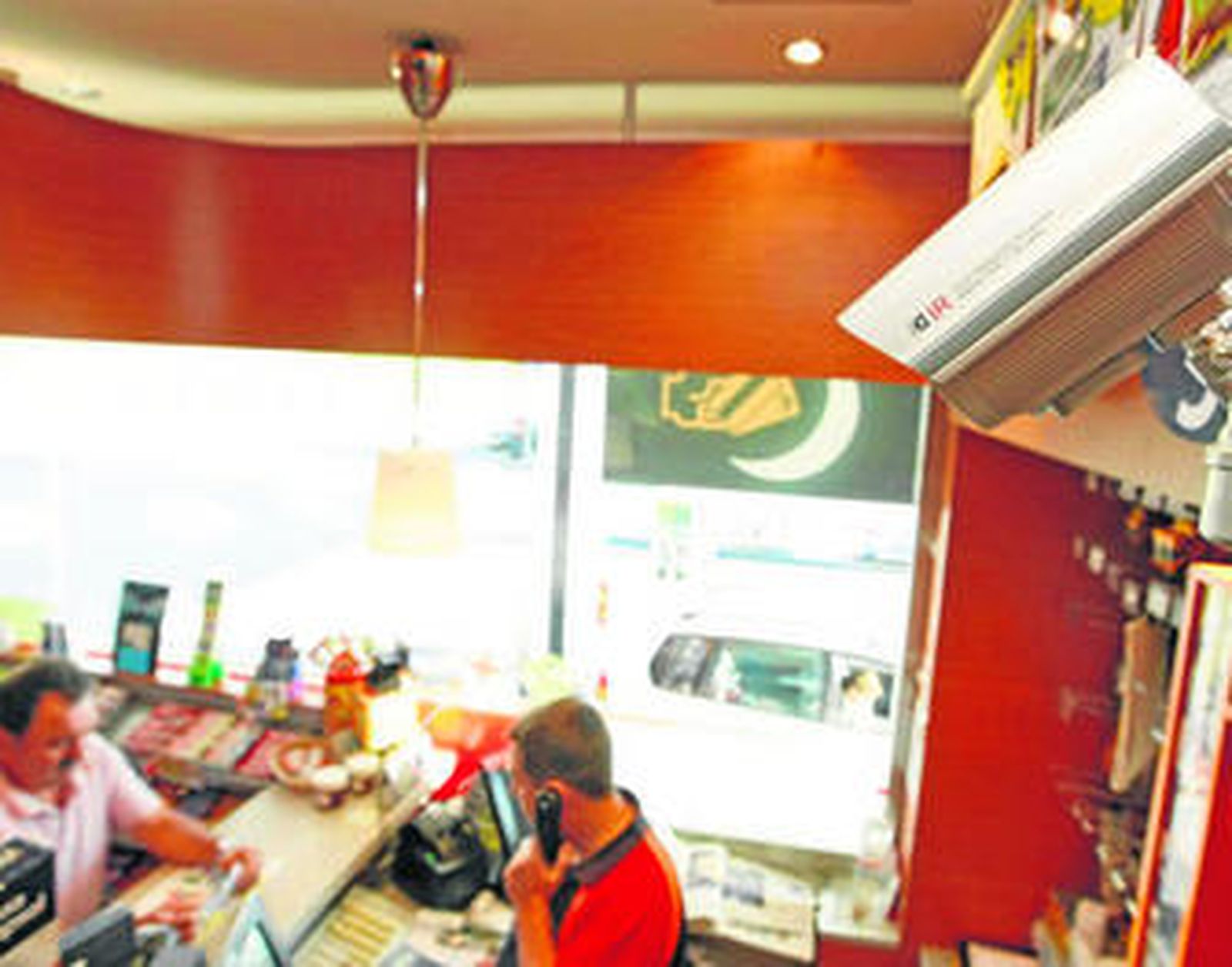 Interior de una estación de servicio Repsol, vigilada por una videocámara.