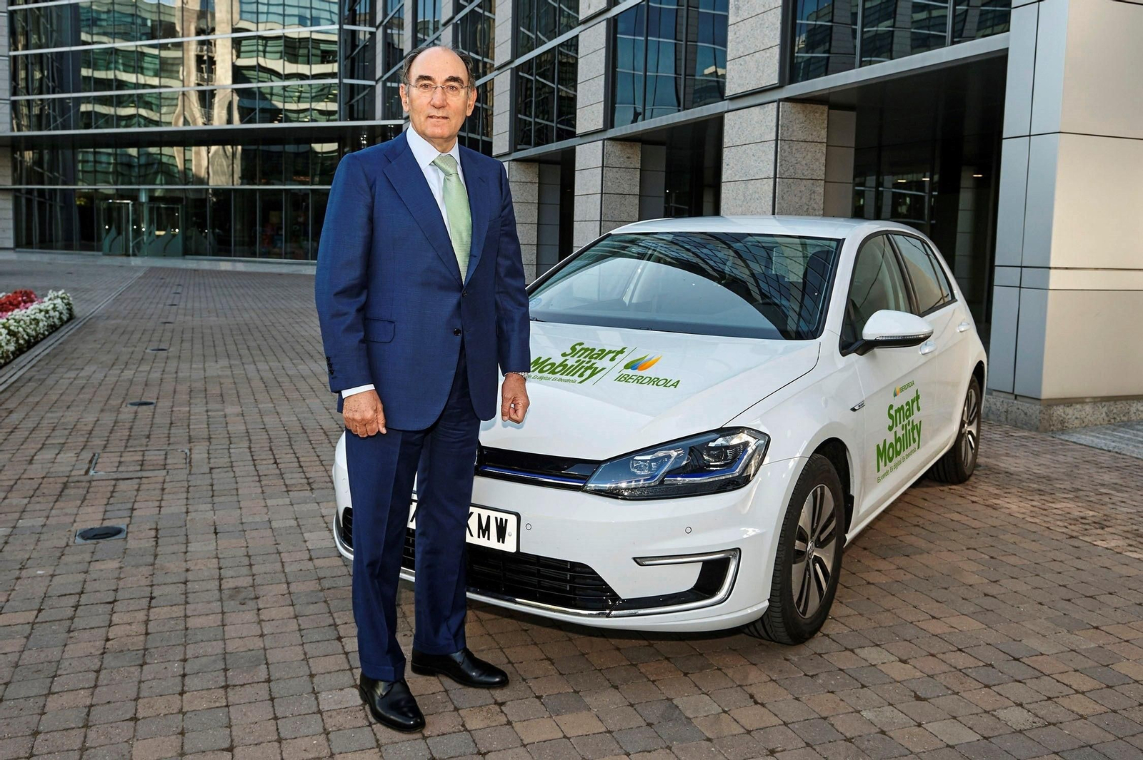 Ignacio Galán, presidente de Iberdrola, posa ante un coche eléctrico.
