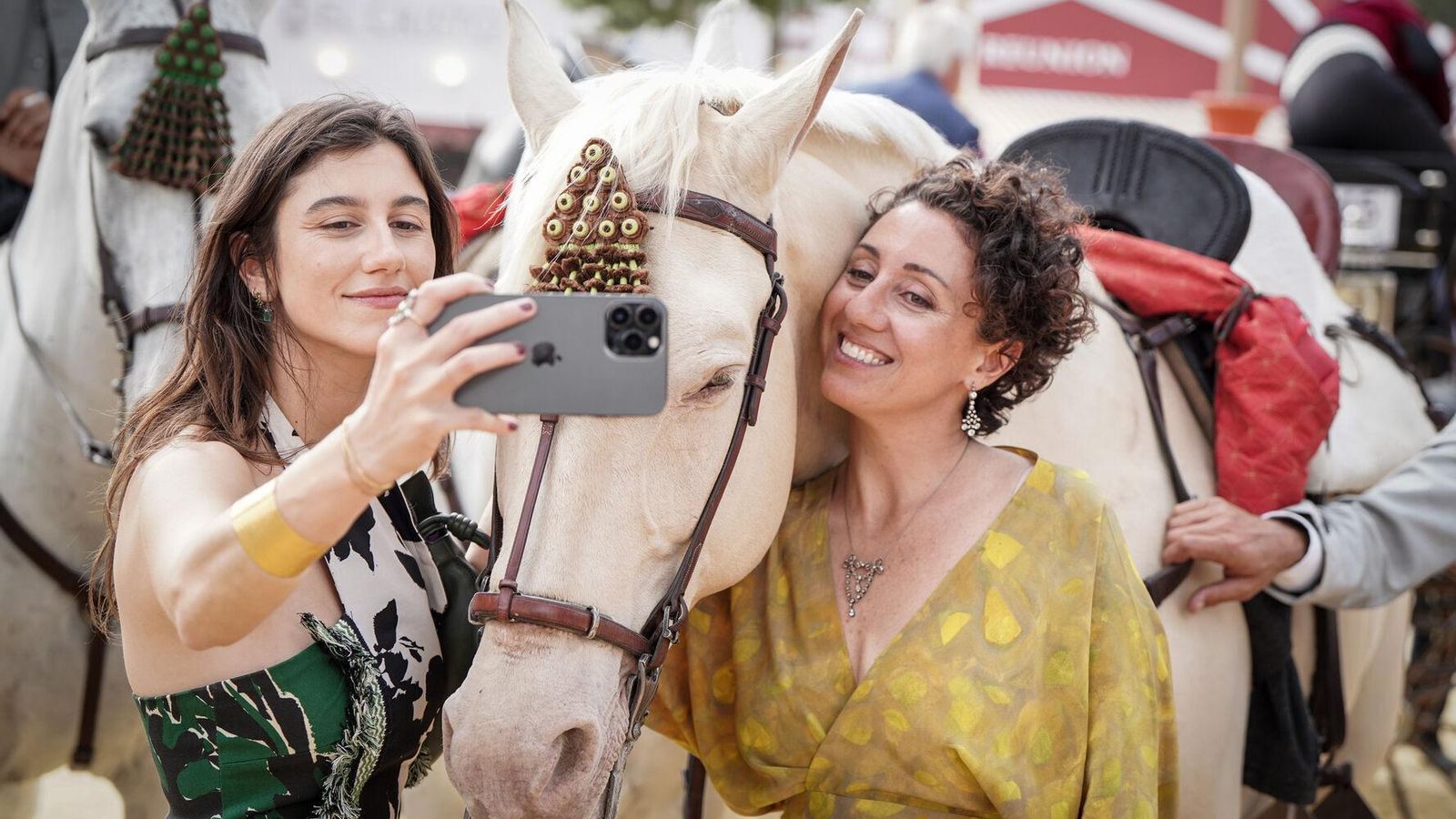 Dos jóvenes fotografiándose con un caballo.