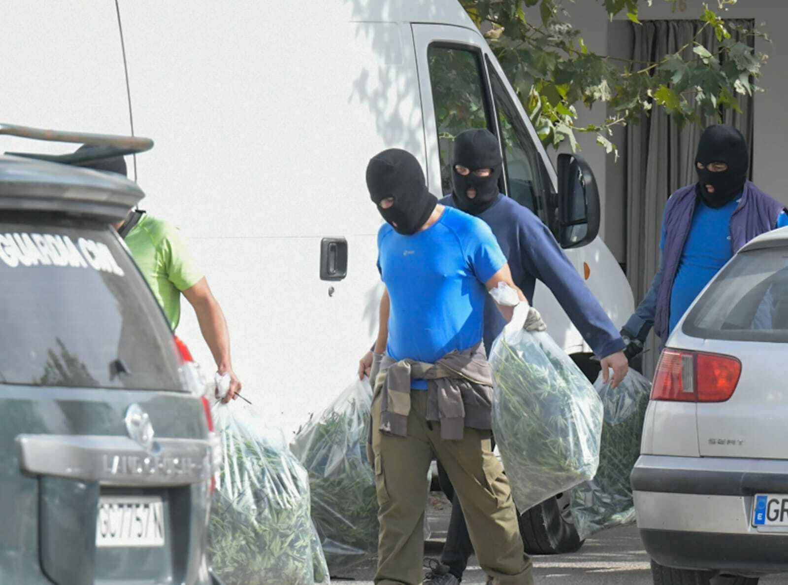 Agentes abandonan una vivienda intervenida con bolsas incautadas llenas de droga