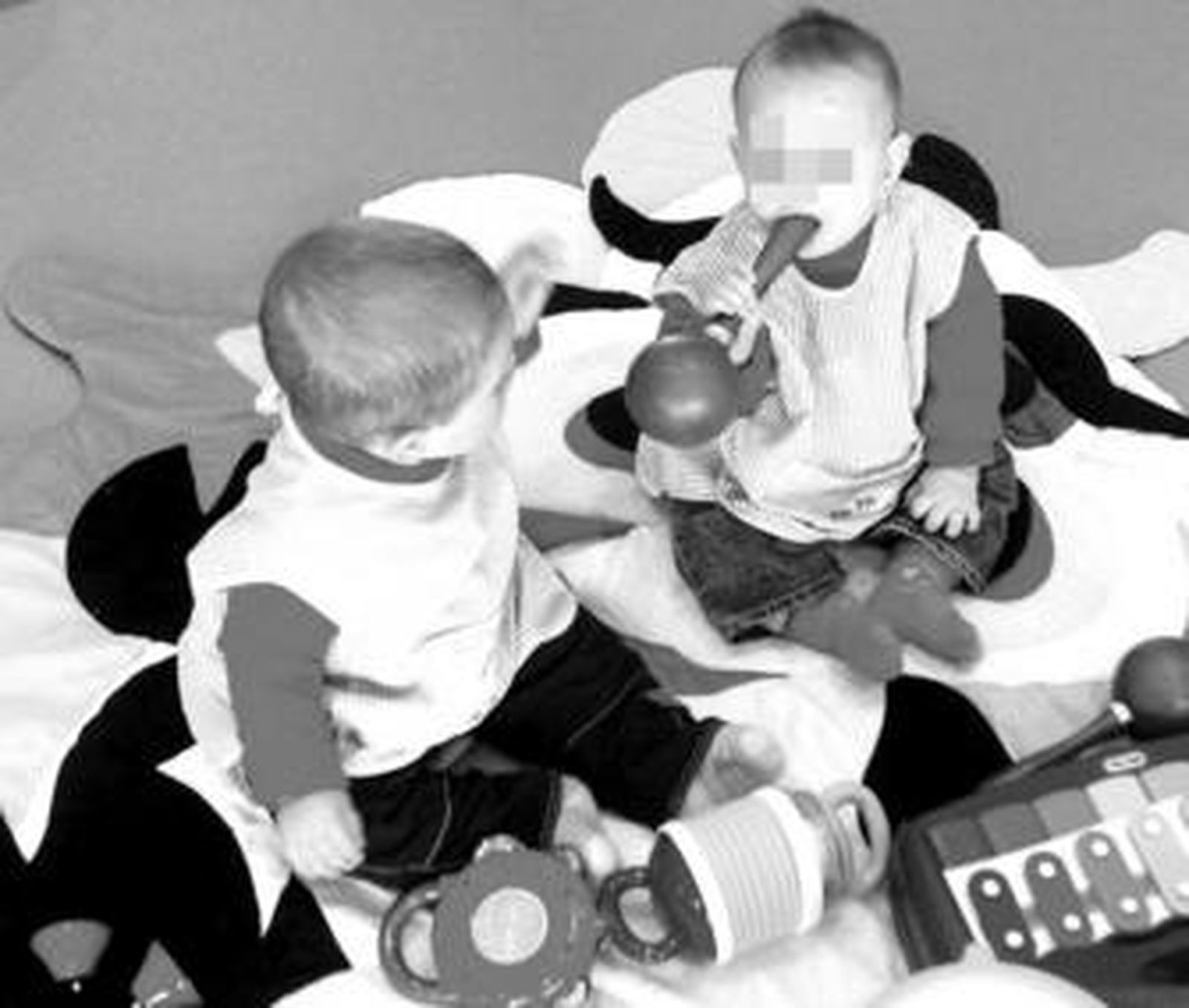 Dos niños de pocos meses juegan en una guardería.