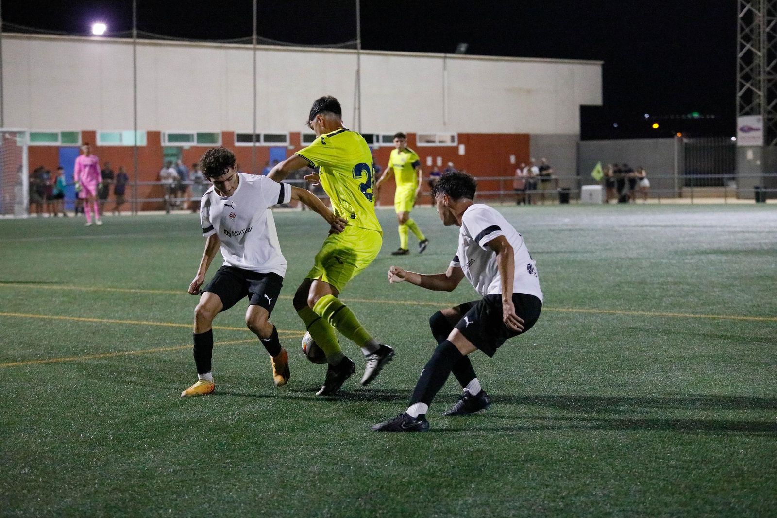 Dos jugadores del conjunto almeriense tratan de frenar el avance de un futbolista del Villarreal durante el Trofeo de Feria Juan Oncala.