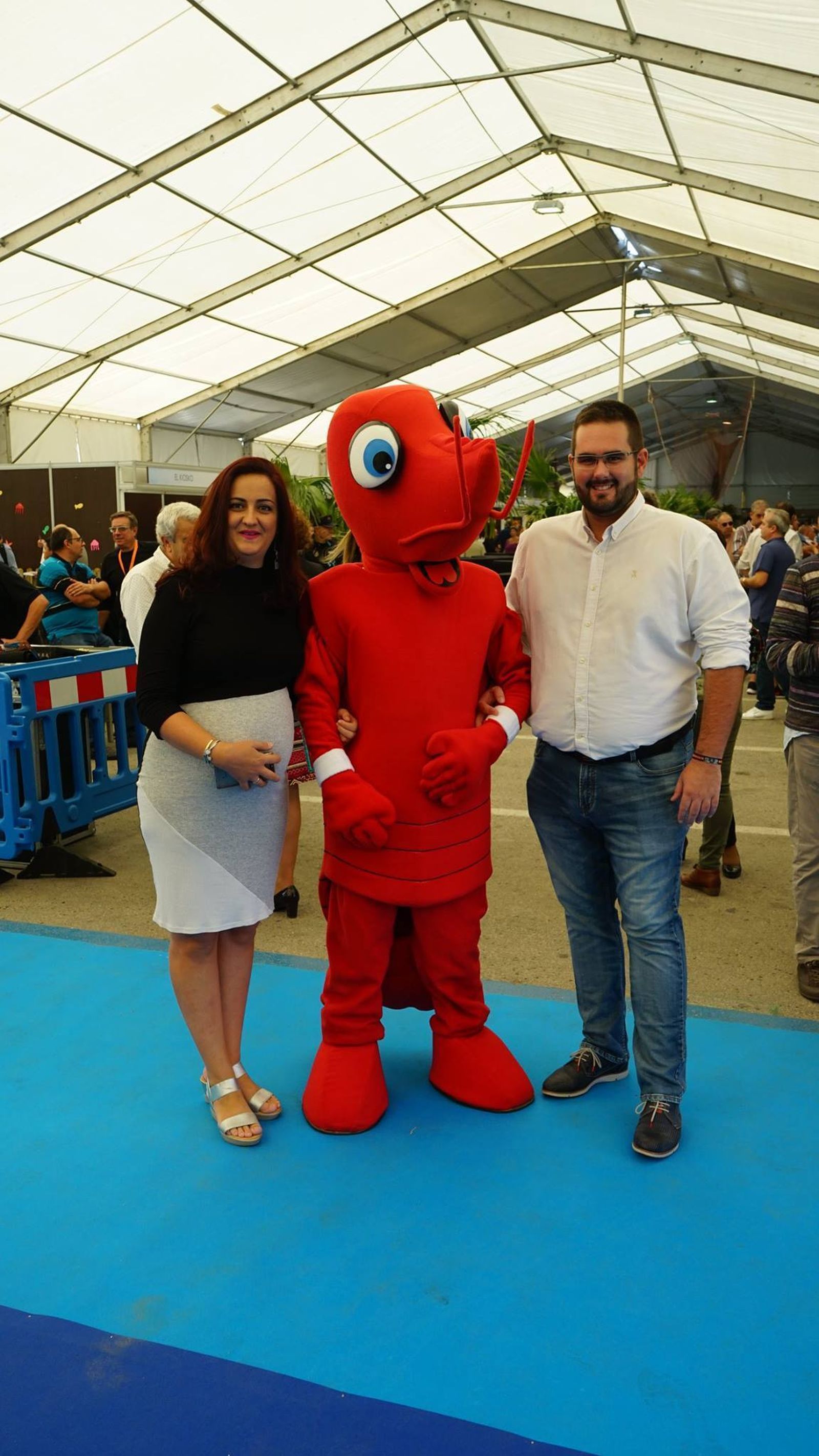La concejal junto a la mascota del festival y un compañero.