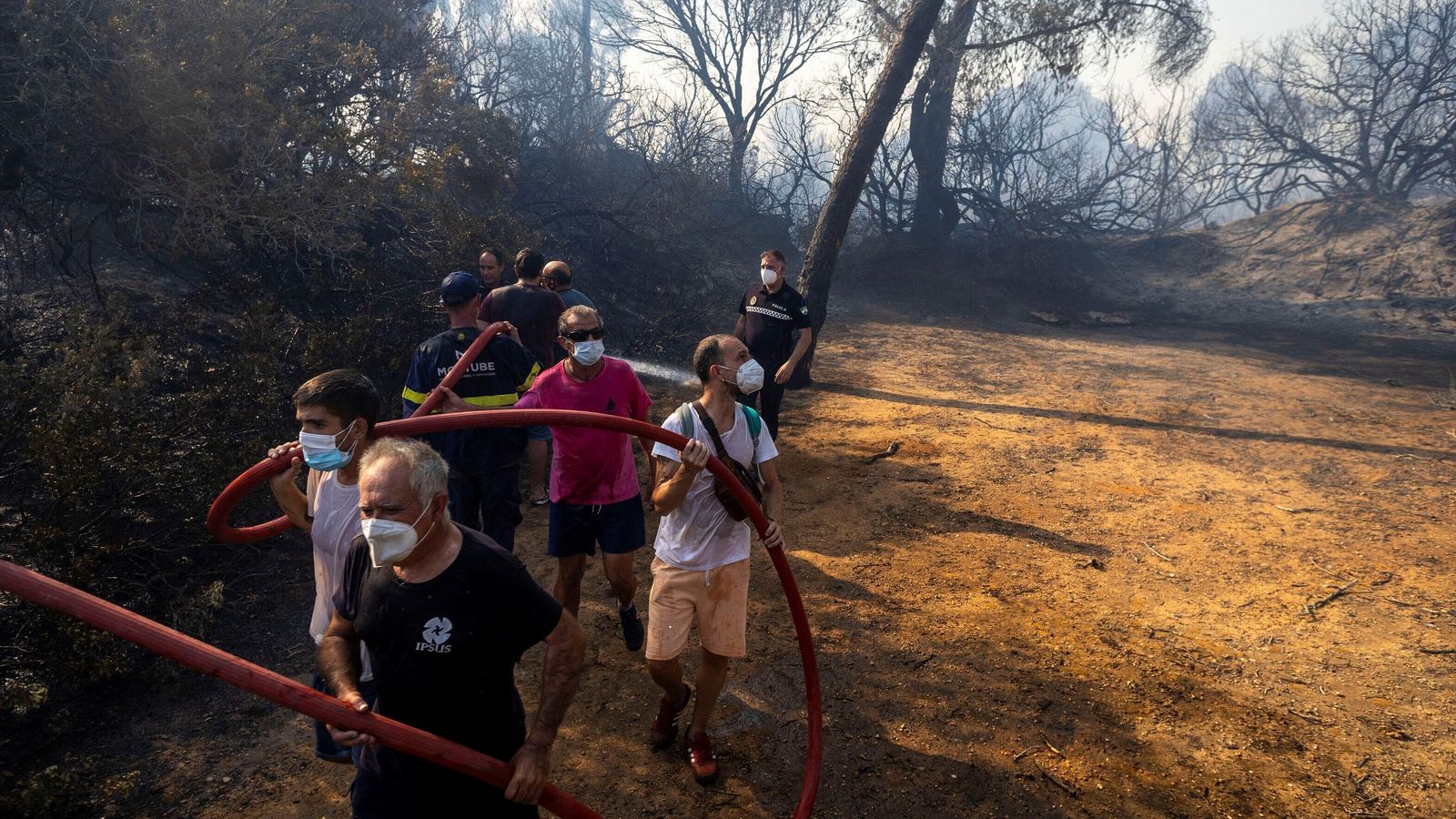 Varias personas con mascarillas ayudan en la extinción del incendio de las Canteras, el 6 de agosto de este año.