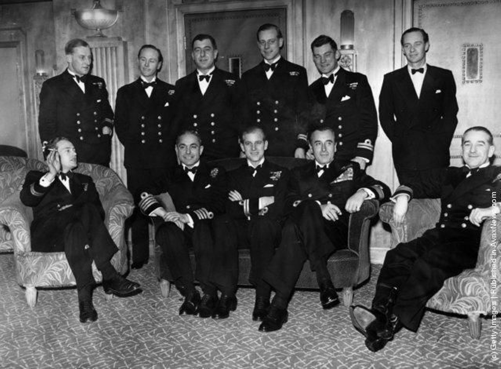 Con uniforme, en compañía de la tripulación de su barco en uno de sus viajes.