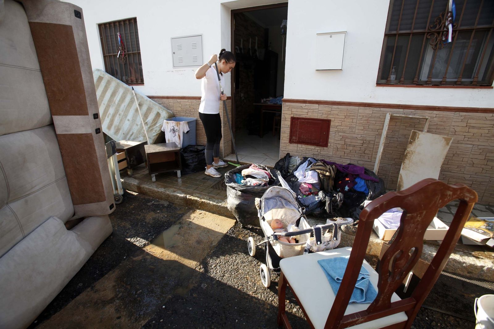 Una vecina de Lepe limpia su casa rodeada de todos los muebles inservibles.