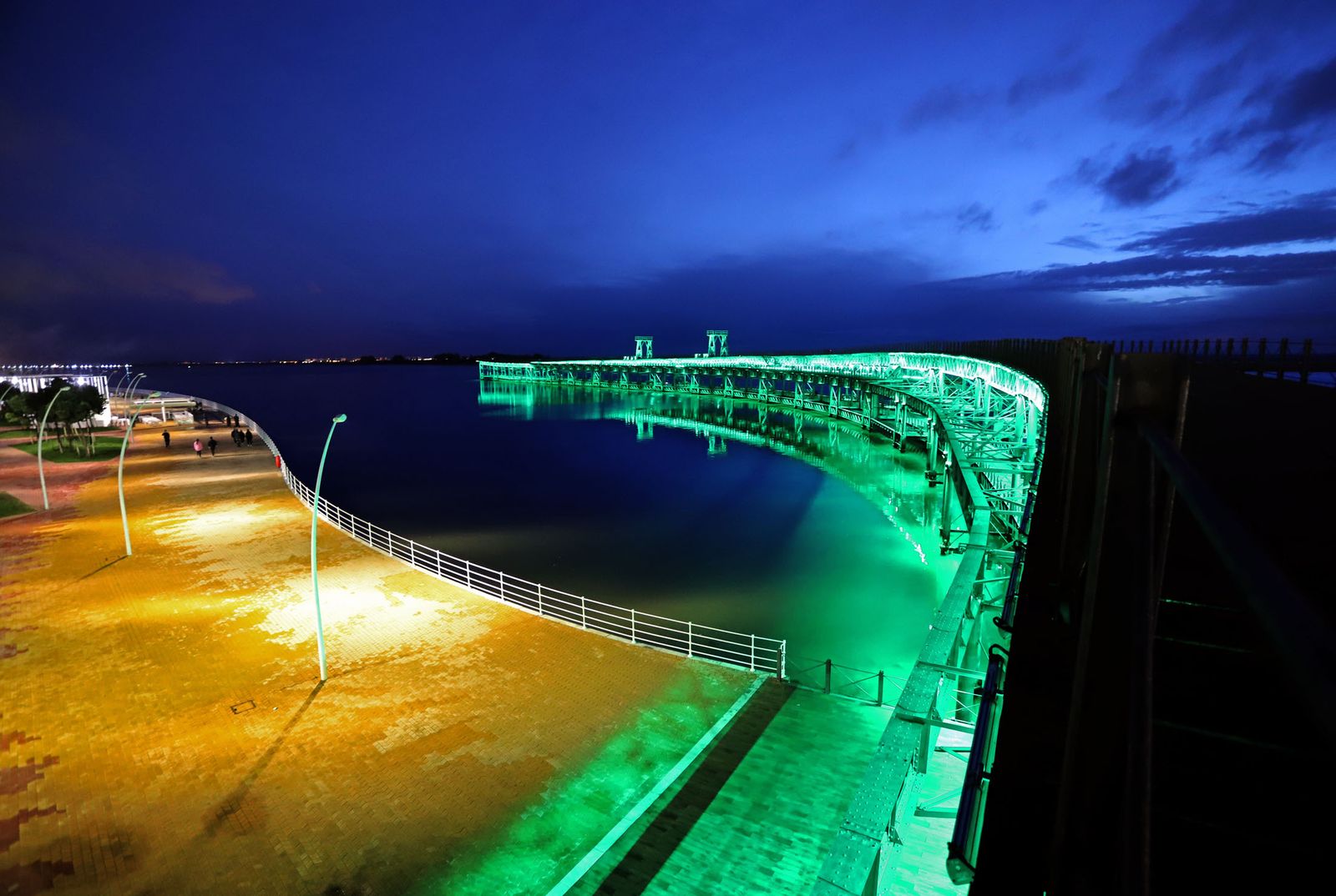 El muelle de la Riotinto se ilumina de verde en el día mundial contra el cancer