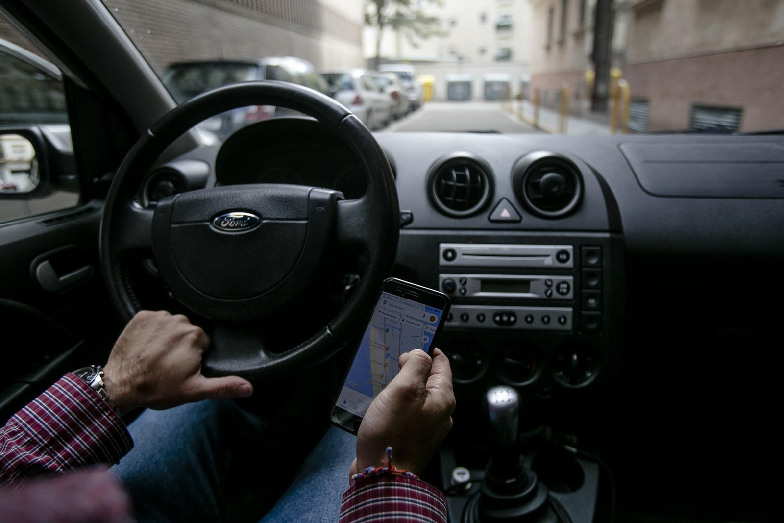 Un conductor mira al móvil mientras conduce.