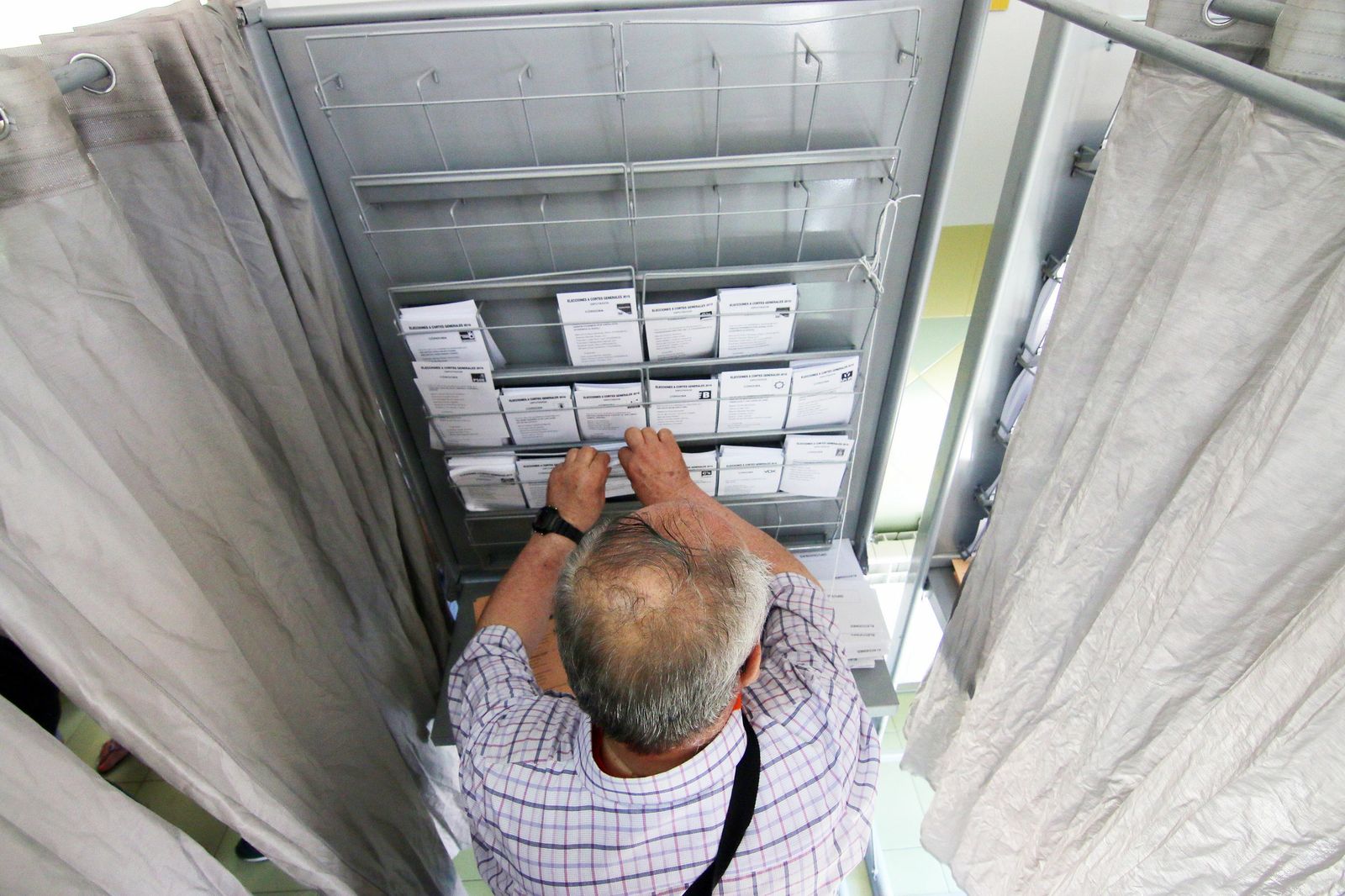 Un votante coge una papeleta en las elecciones generales de 2016.