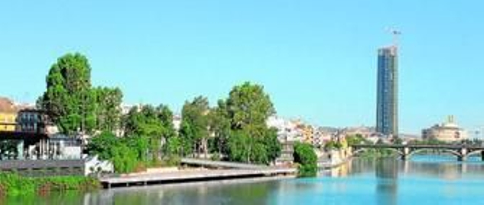 Panorámica del Guadalquivir, con la pasarela flotante en primer plano y, al fondo, el puente de Triana y la Torre Pelli.