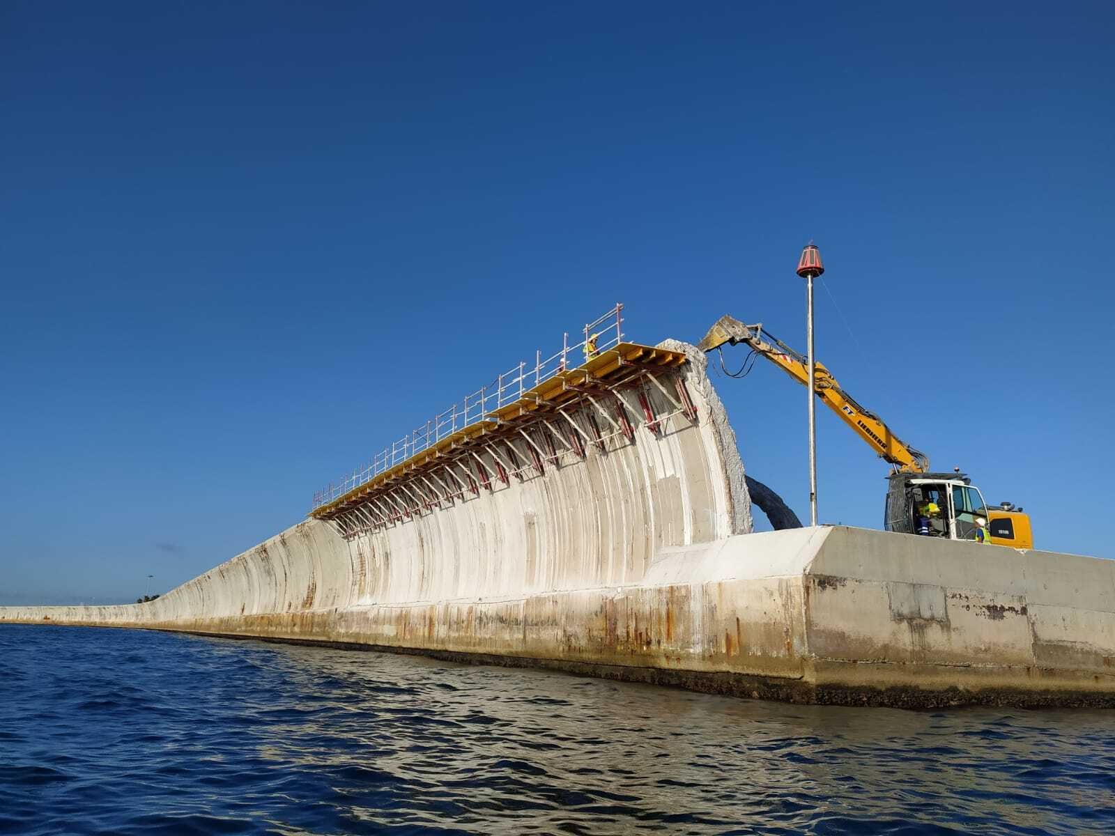 Una máquina trabaja en el Dique de Levante.