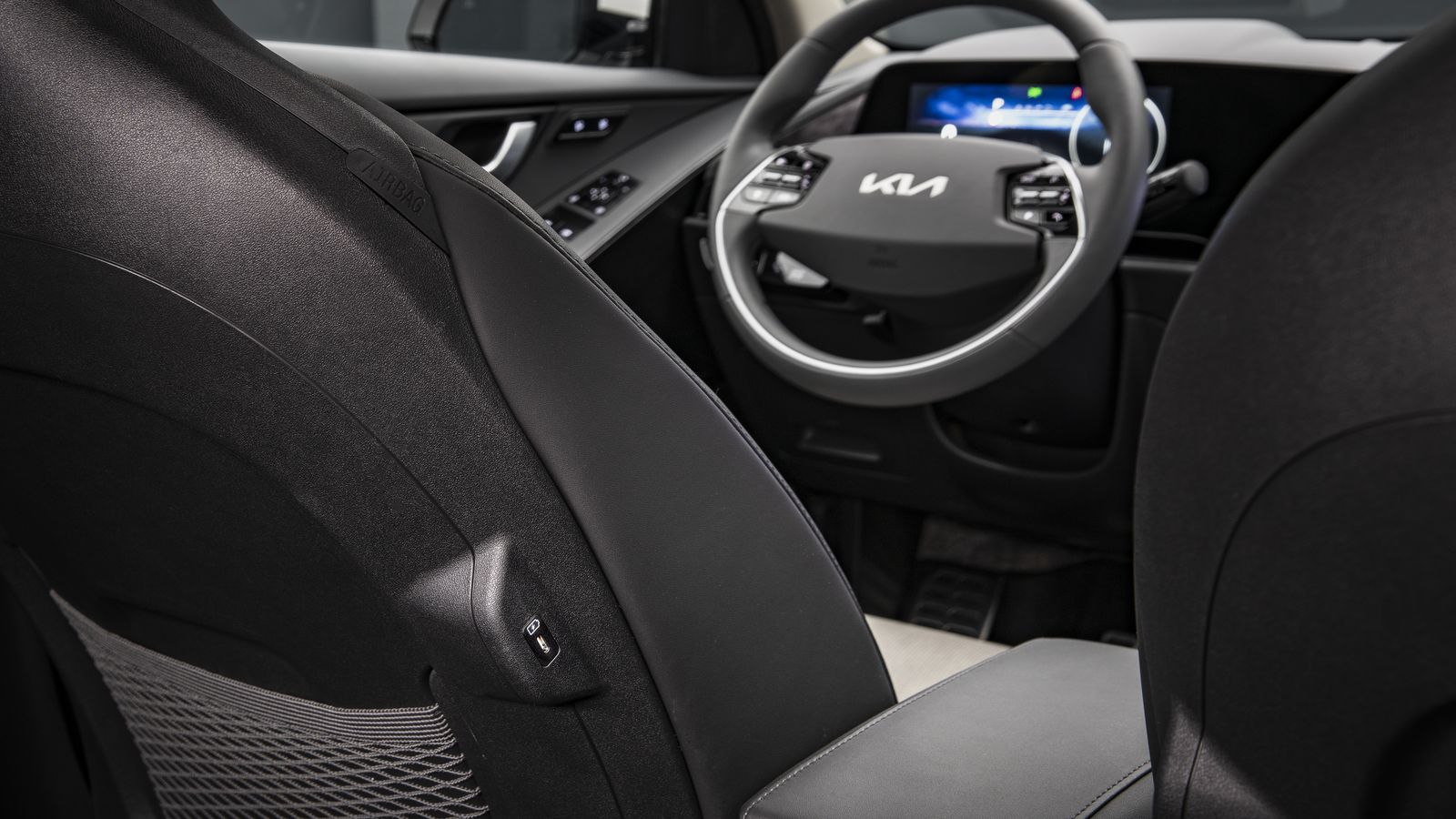 Los enveses de los asientos delanteros están revestidos de material plástico y, junto a la bolsa de canguro de red están los puertos USB-C.