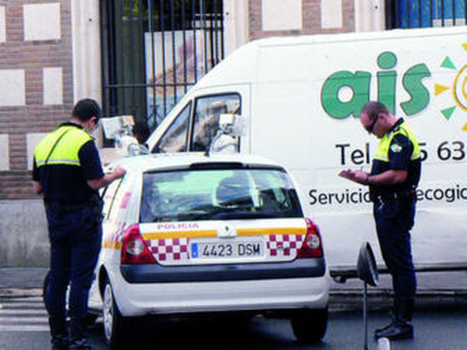 Dos policías multan a una furgoneta estacionada en la Plaza de la Magdalena.