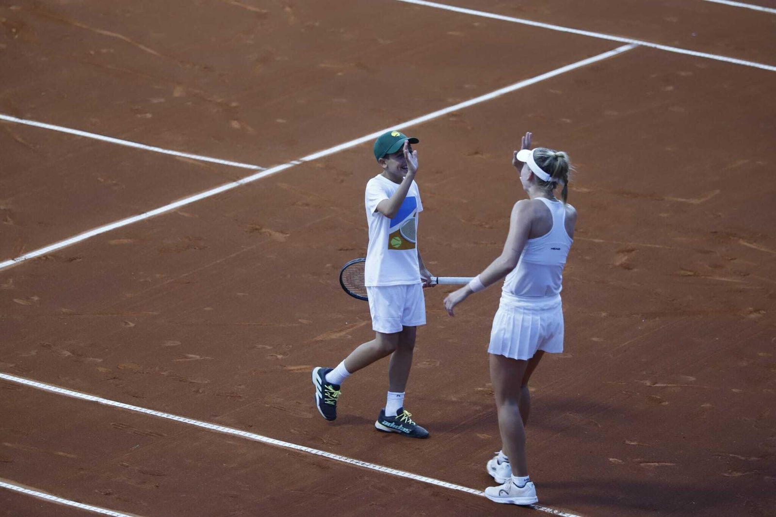 Jil Teichmann felicita al joven recogepelotas tras cederle la raqueta y ganar el punto.