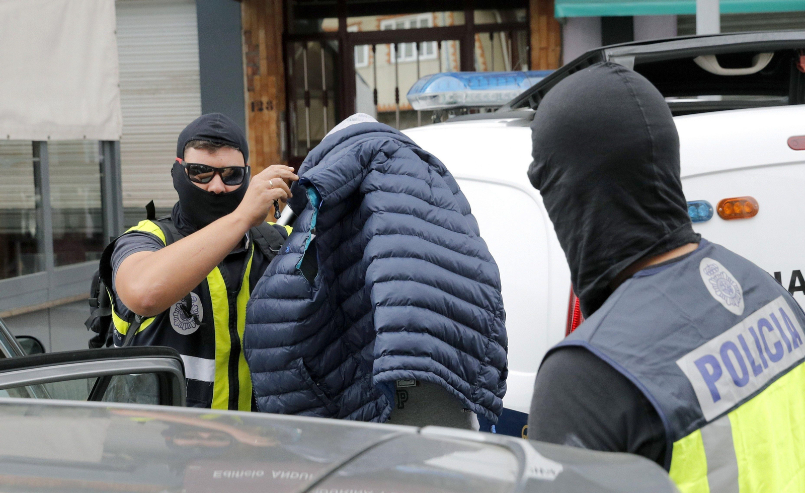 Dos agentes trasladan a un detenido ayer en un local de Boiro (La Coruña).