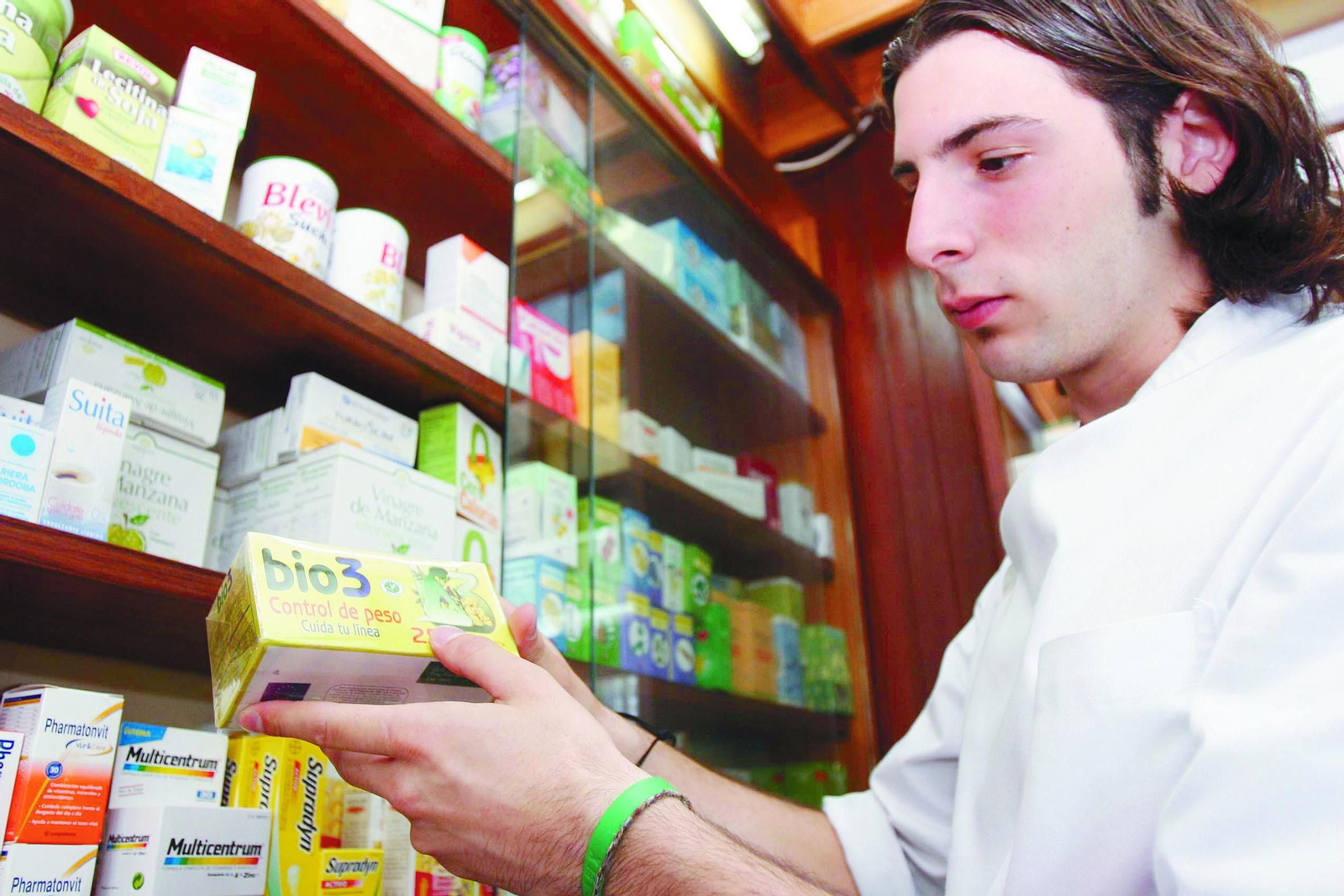Un farmacéutico sostiene un producto dietético basado en plantas  medicinales .