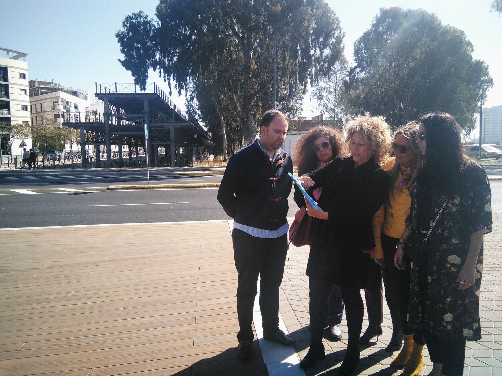 Pilar Marín y varios miembros de su equipo, con el tramo terrestre del muelle detrás.