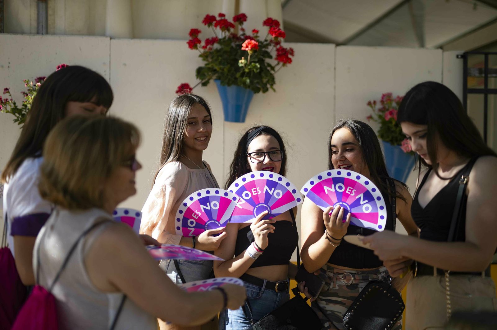 Unas voluntarias reparten abanicos en una caseta.