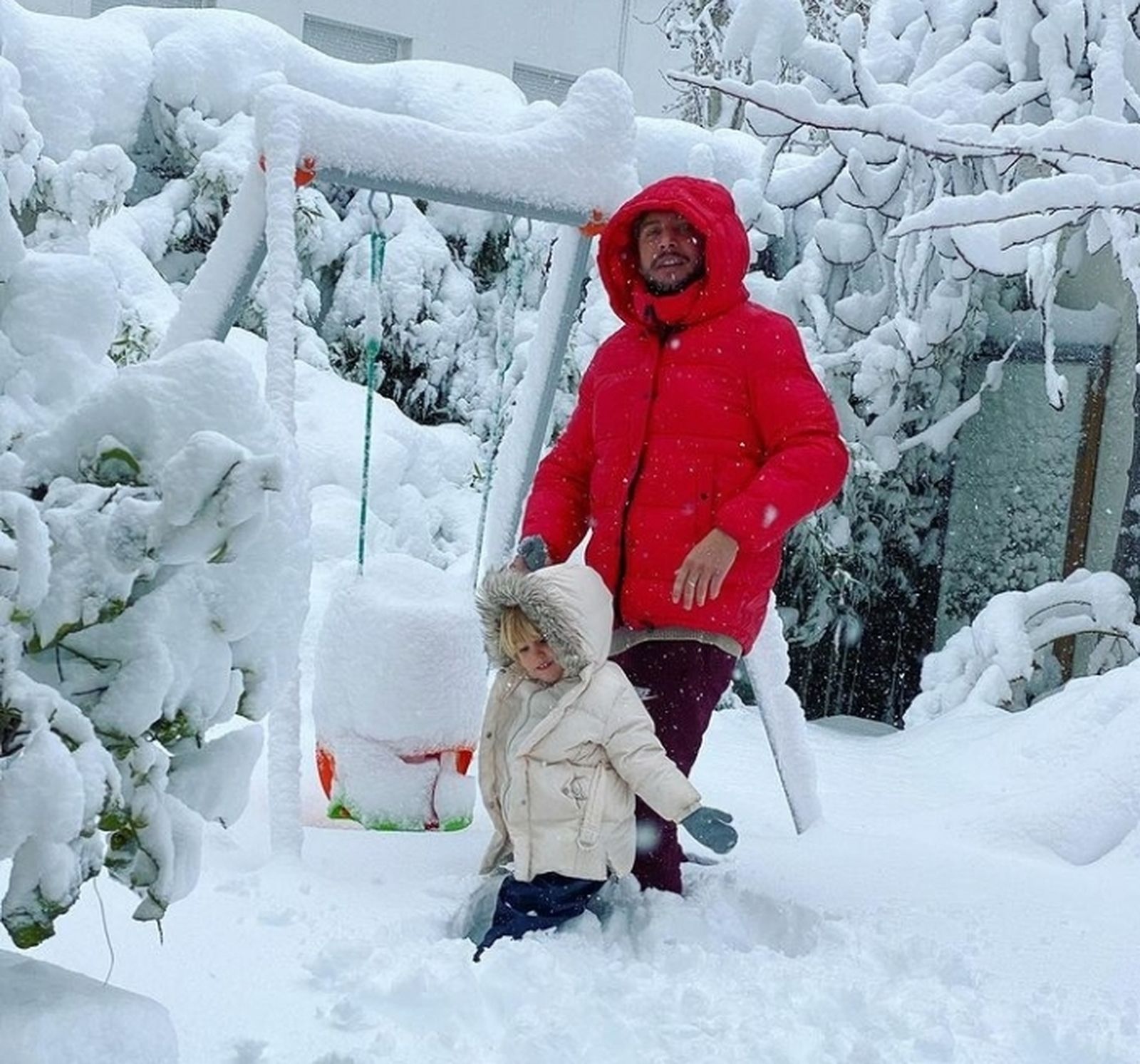 Manolo Carrasco con su hijo entre los carámbanos de su casa