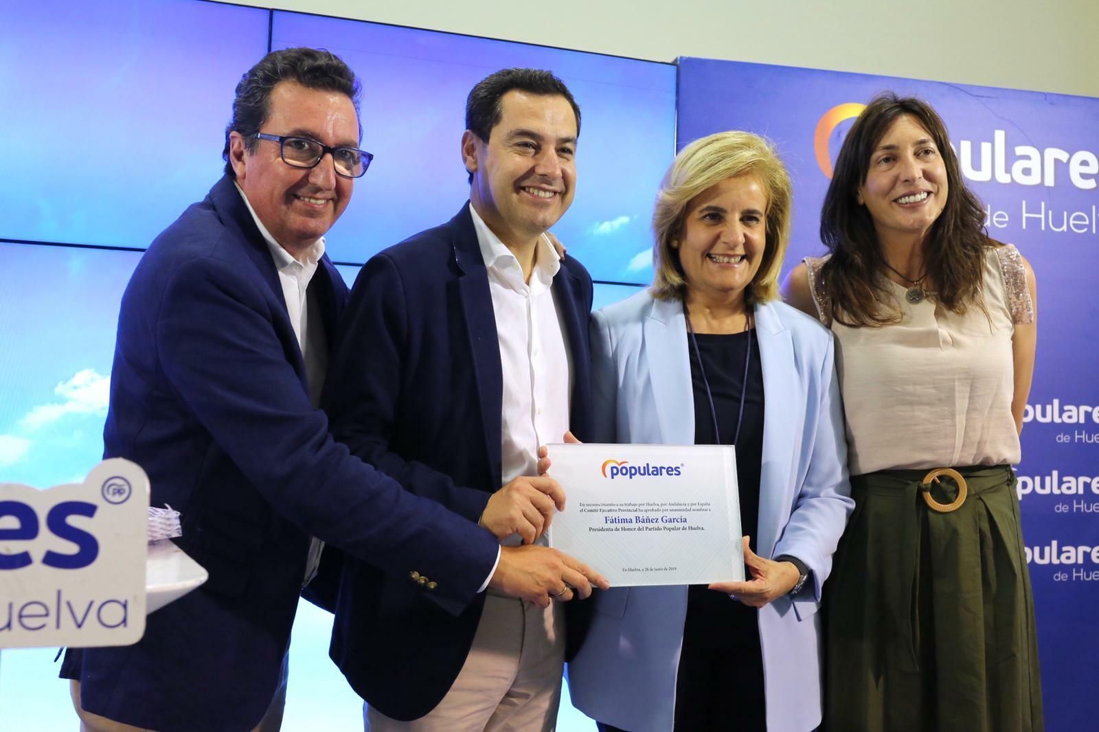 Fátima Báñez posa con la placa de presidenta de honor del PP onubense junto a Juanma Moreno, Loles López y Manuel Andrés González.