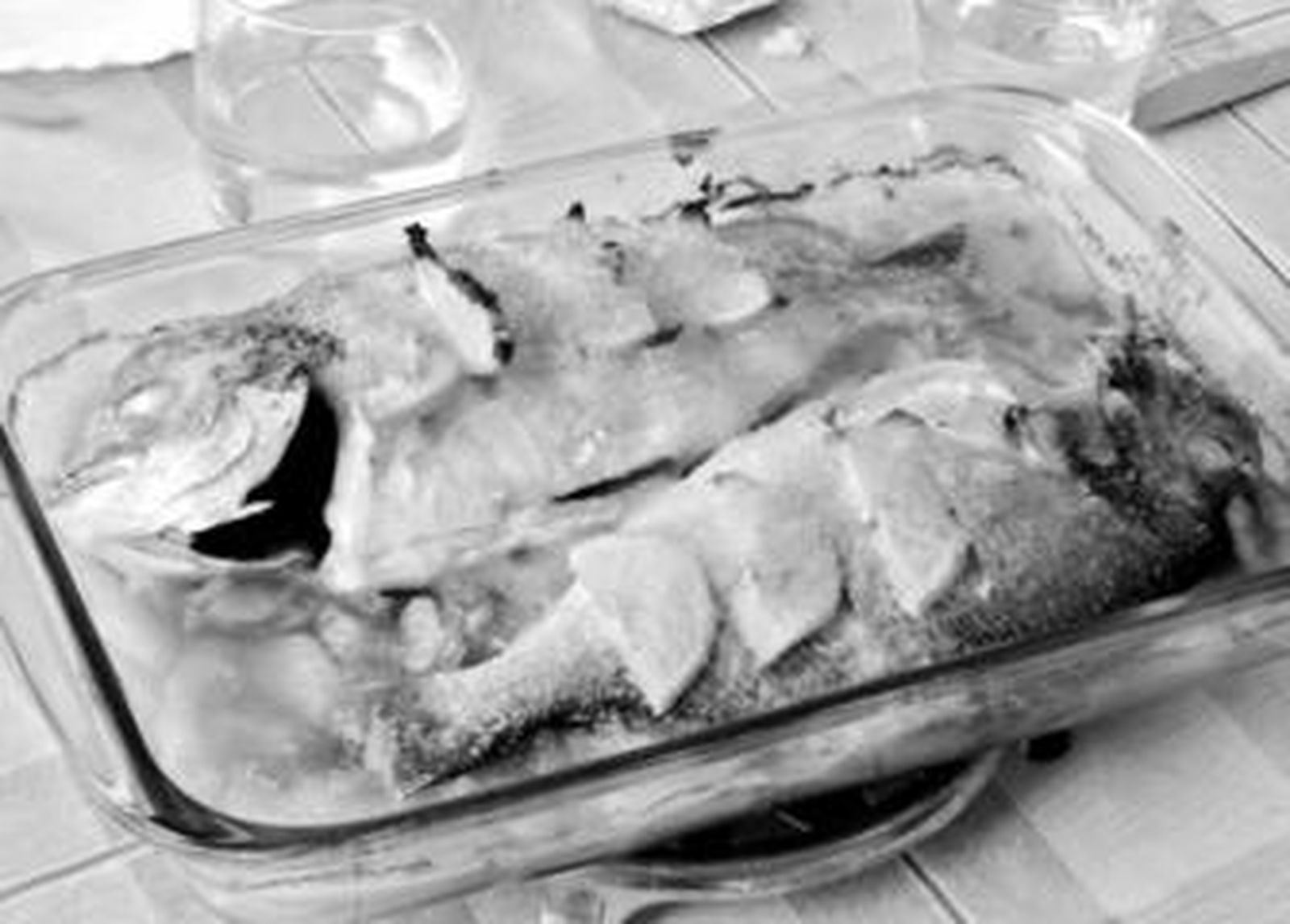 Una fuente de pescado con patatas al horno.