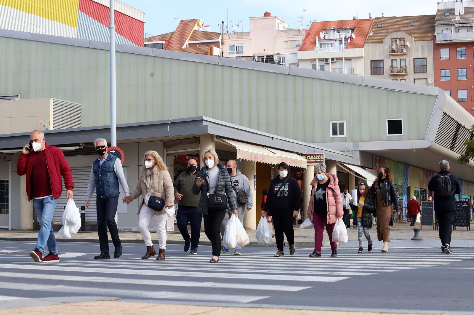 Varias personas caminan junto al Mercado del Carmen de la capital onubense.