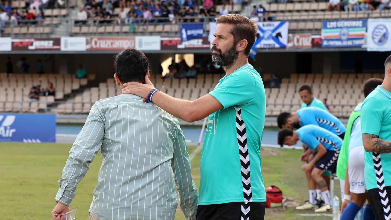 David Sánchez saluda al delegado de campo azulino al inicio del partido.