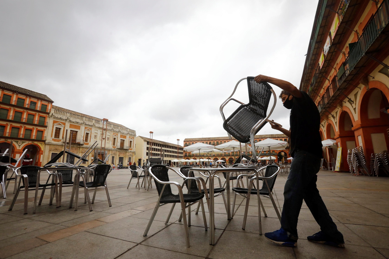 Un camarero recoge la terraza en un bar de la Corredera.