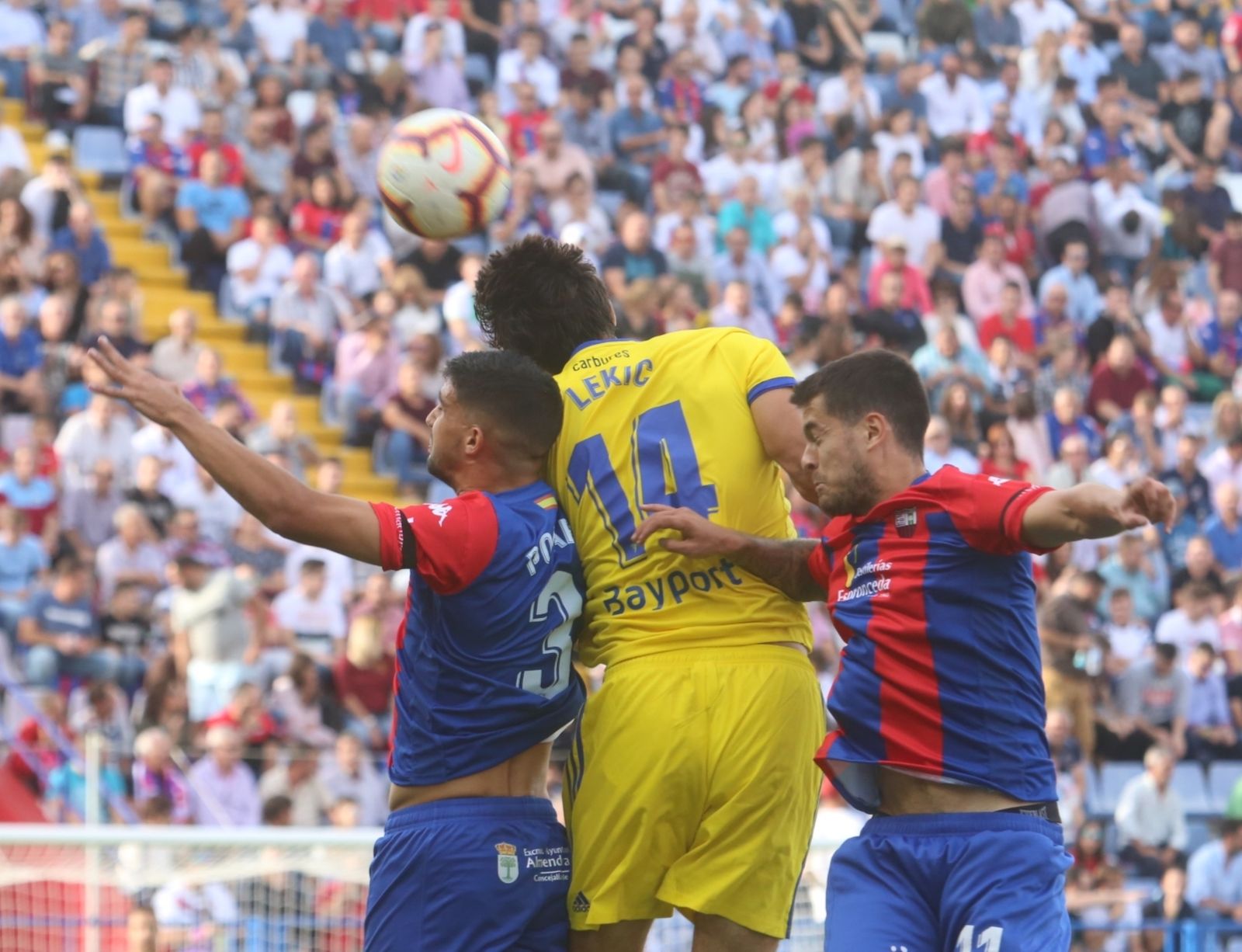Lekic salta entre dos jugadores del Extremadura en busca del balón.
