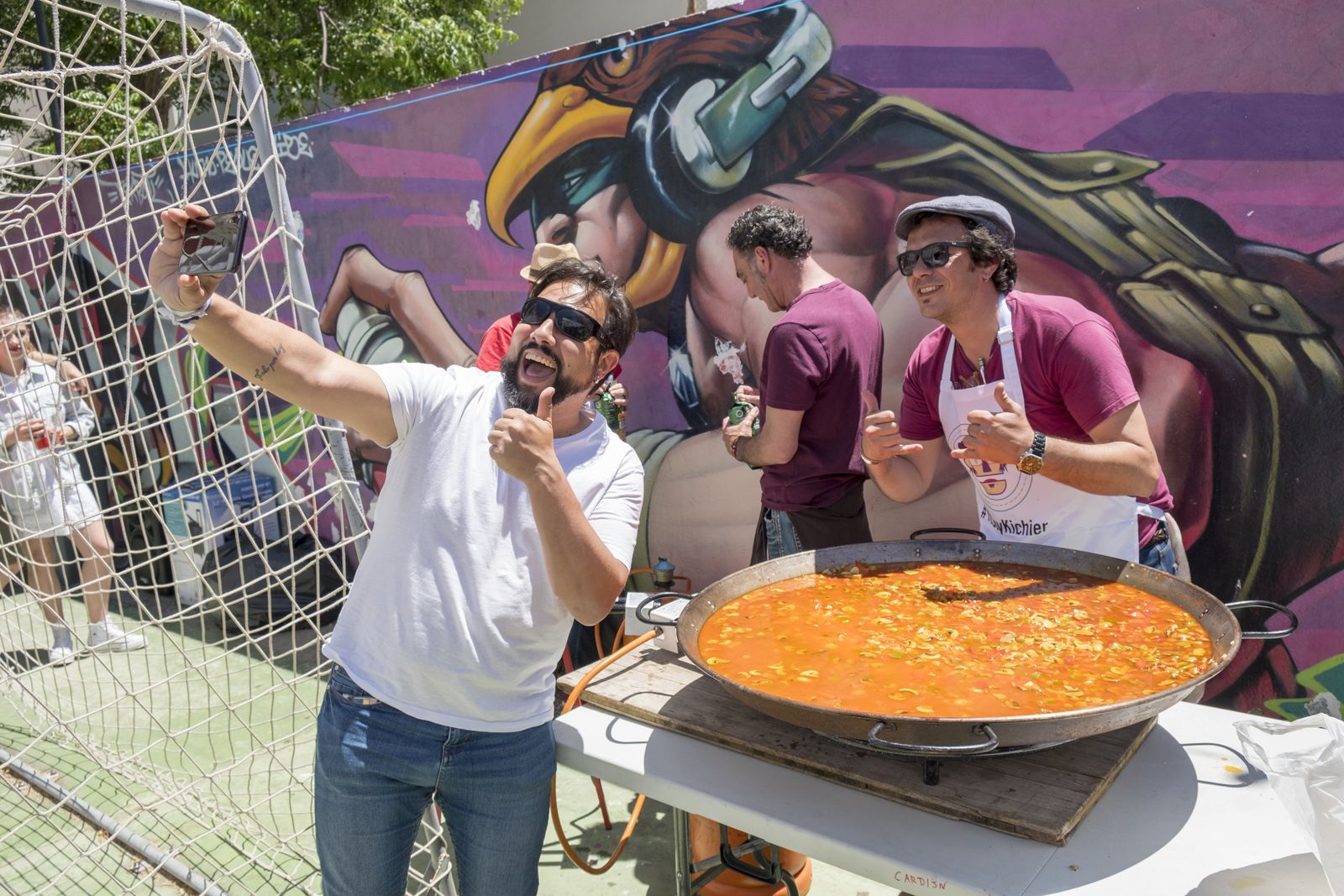 El candidato de Adelante Cádiz, José María González, se hace un selfi con un simpatizante mientras que prepara un arroz.