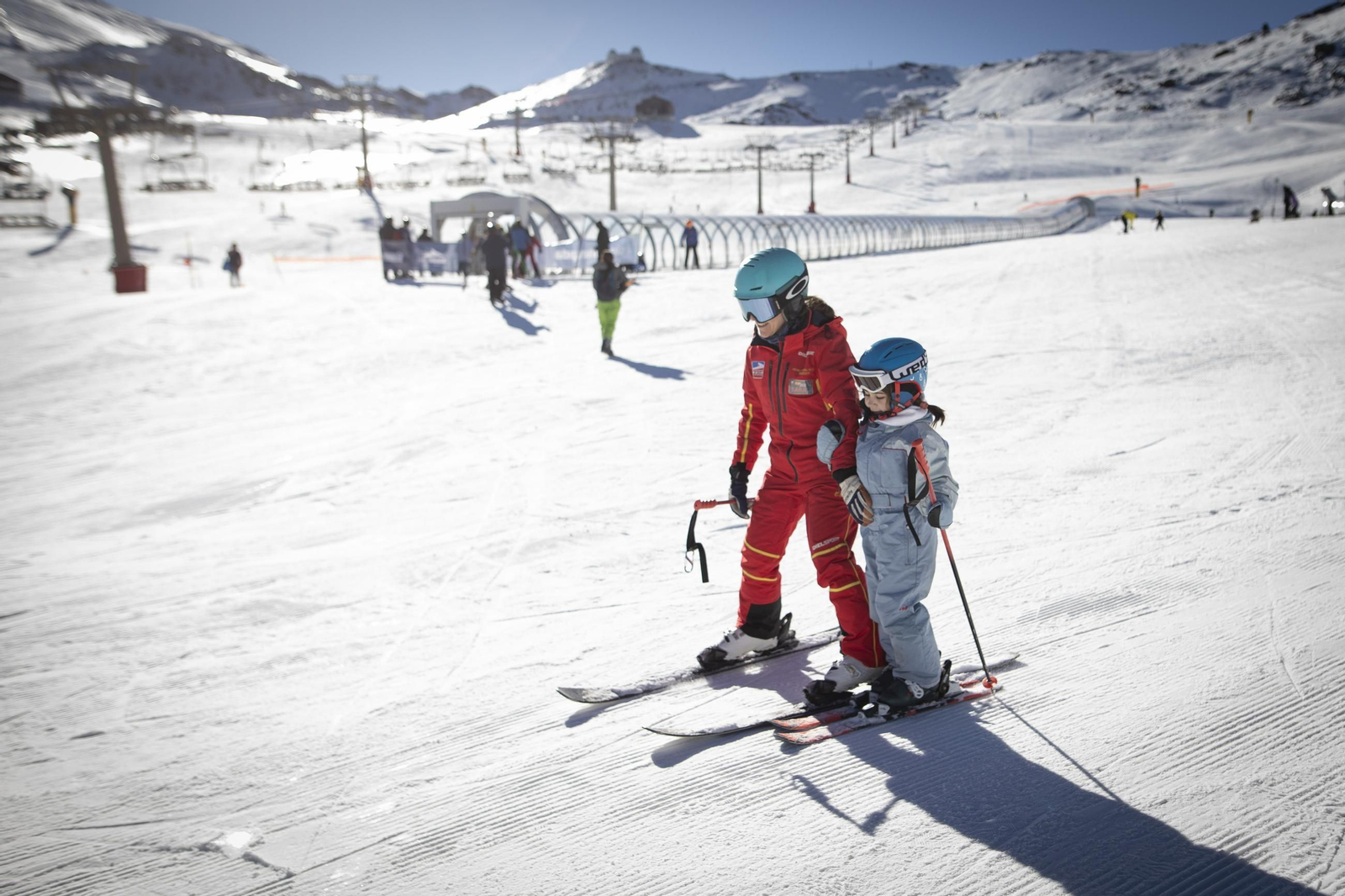 Un profesor de esquí junto a un niño en la zona de Borreguiles de Sierra Nevada