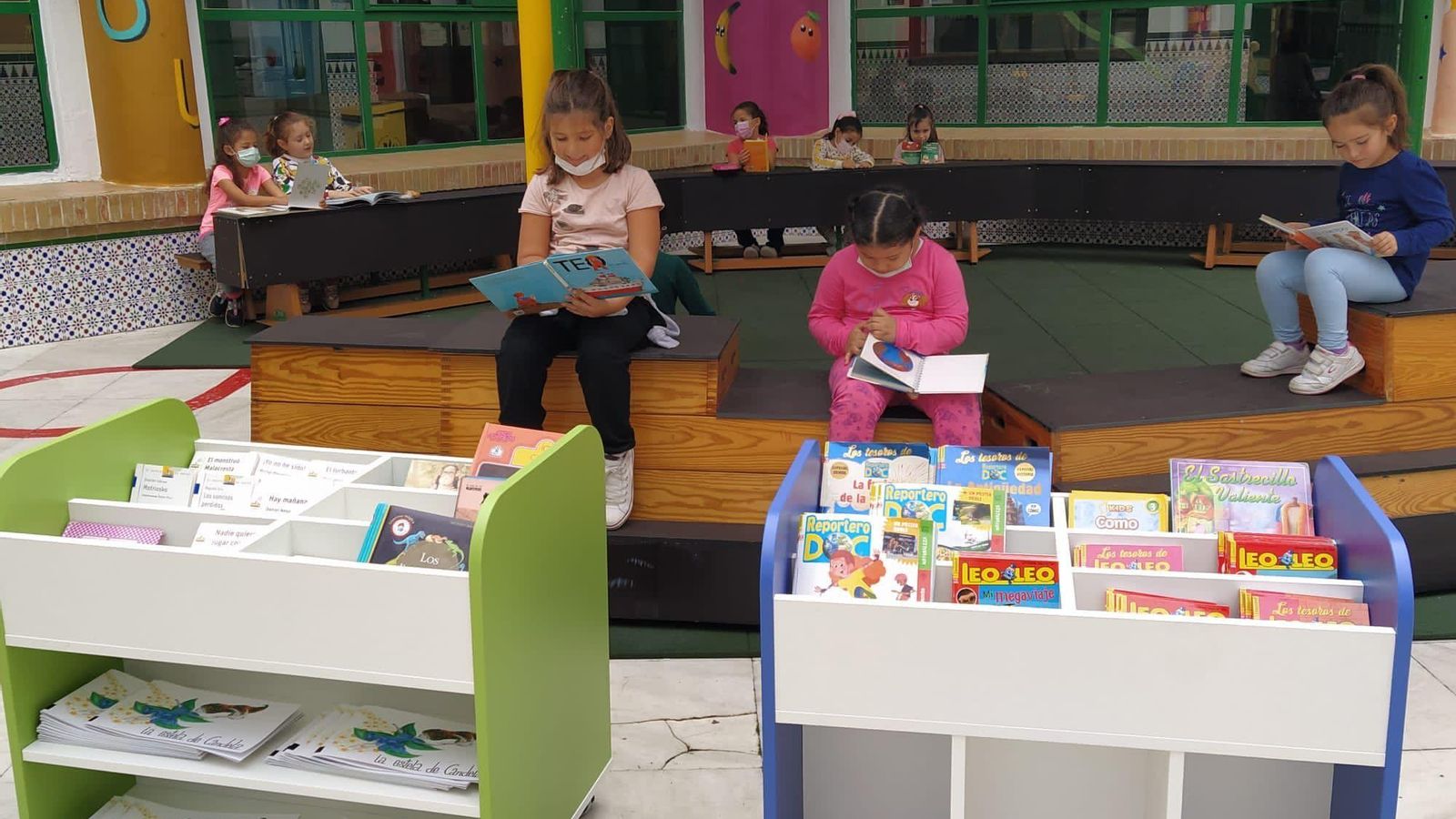 Varios alumnos, leyendo en el aula al aire libre del centro.