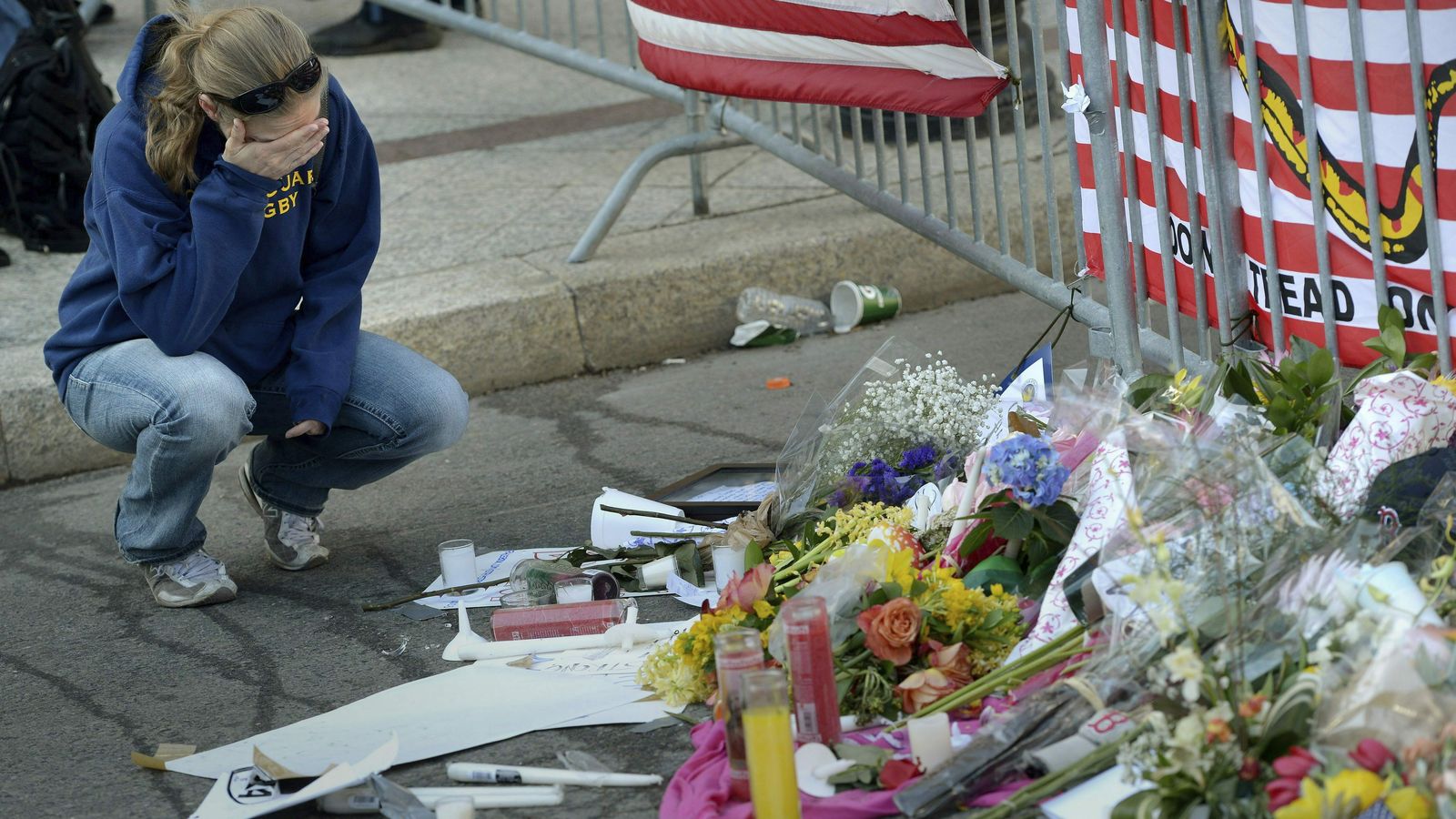 Una mujer llora ante las flores y las velas dejadas en memoria de las víctimas del atentado de la maratón de Boston.