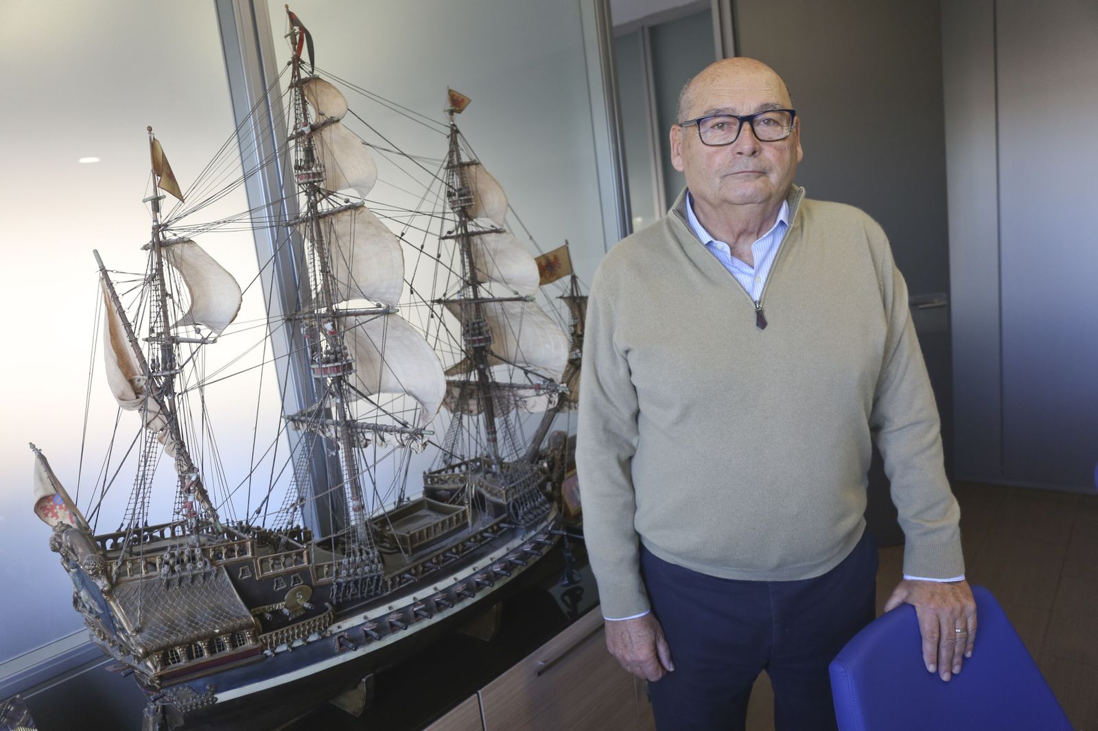 El armador posa delante de una maqueta en las instalaciones de su empresa.