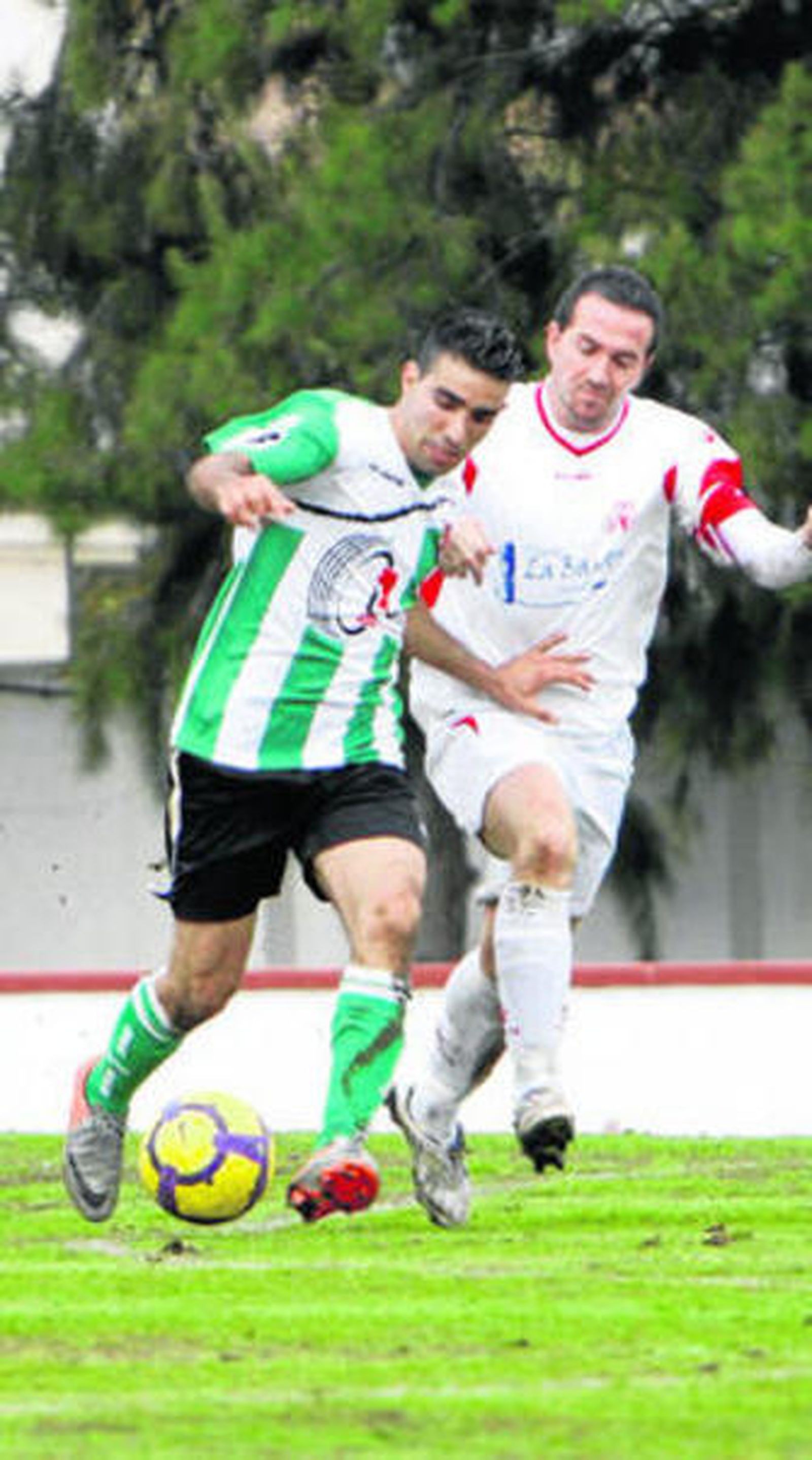 El local Flores (d) intenta arrebatar el balón a un contrario.
