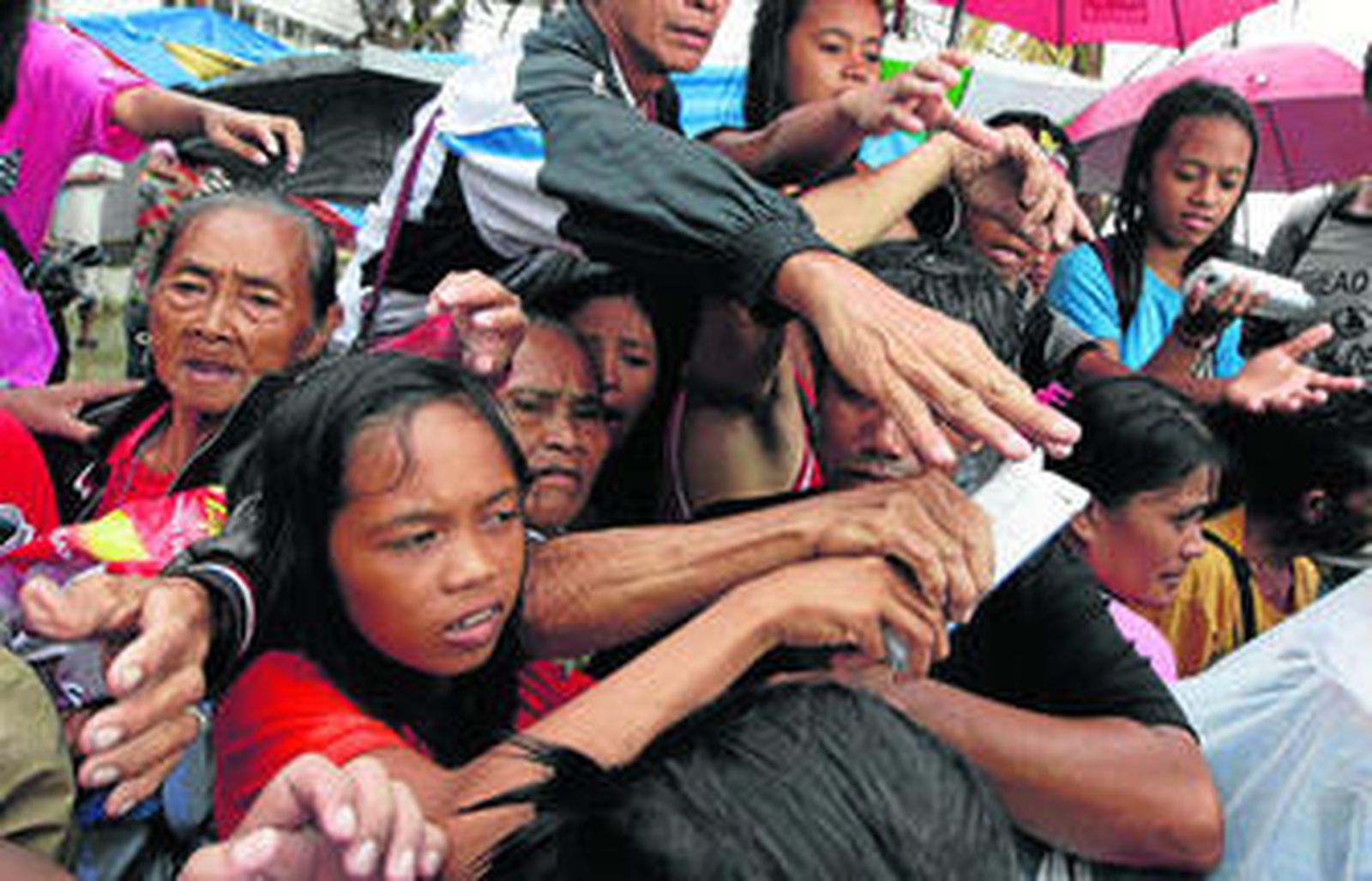 Supervivientes del tifón 'Haiyan' reciben artículos de primera necesidad en la localidad filipina de Tacloban.