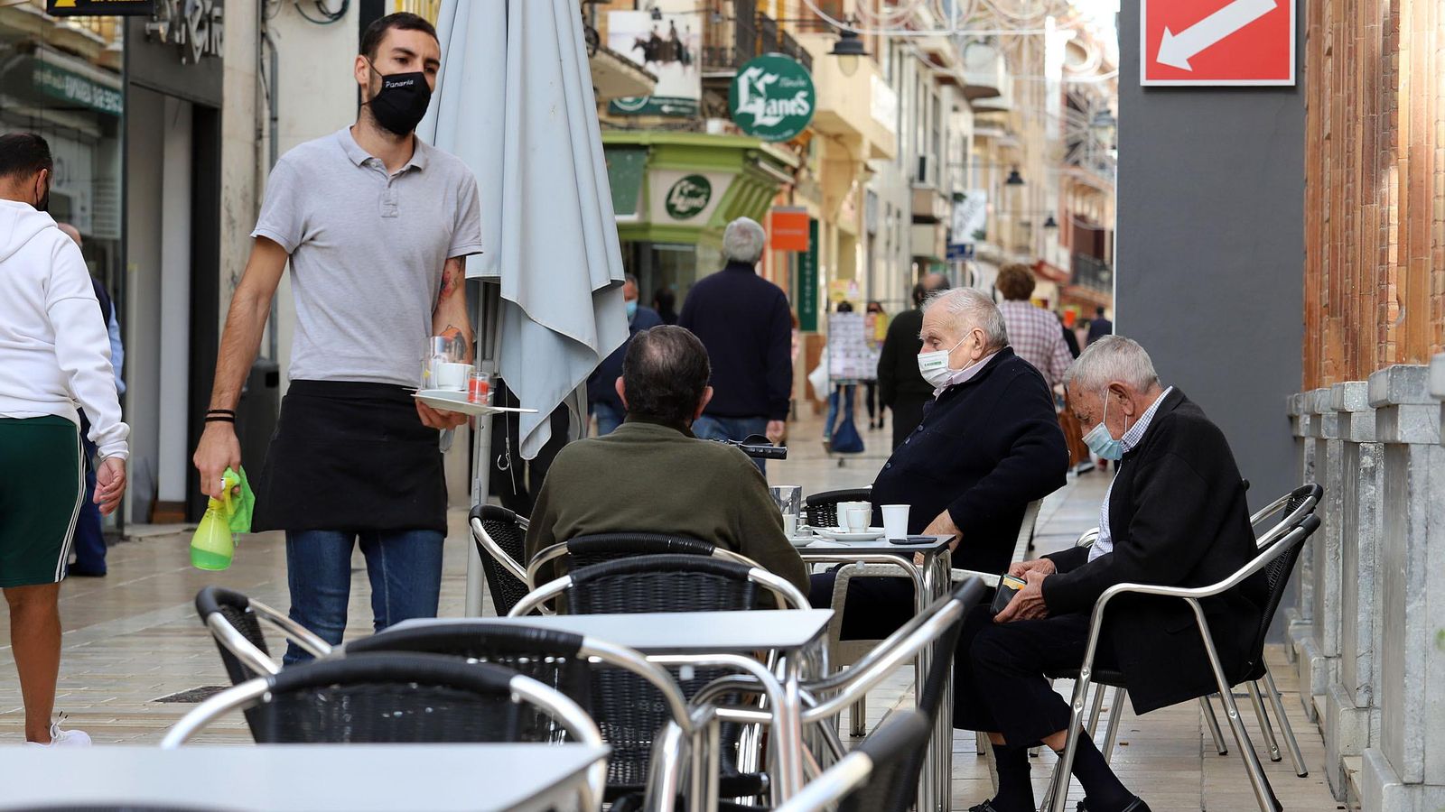 Un camarero atiende a una mesa en un bar.